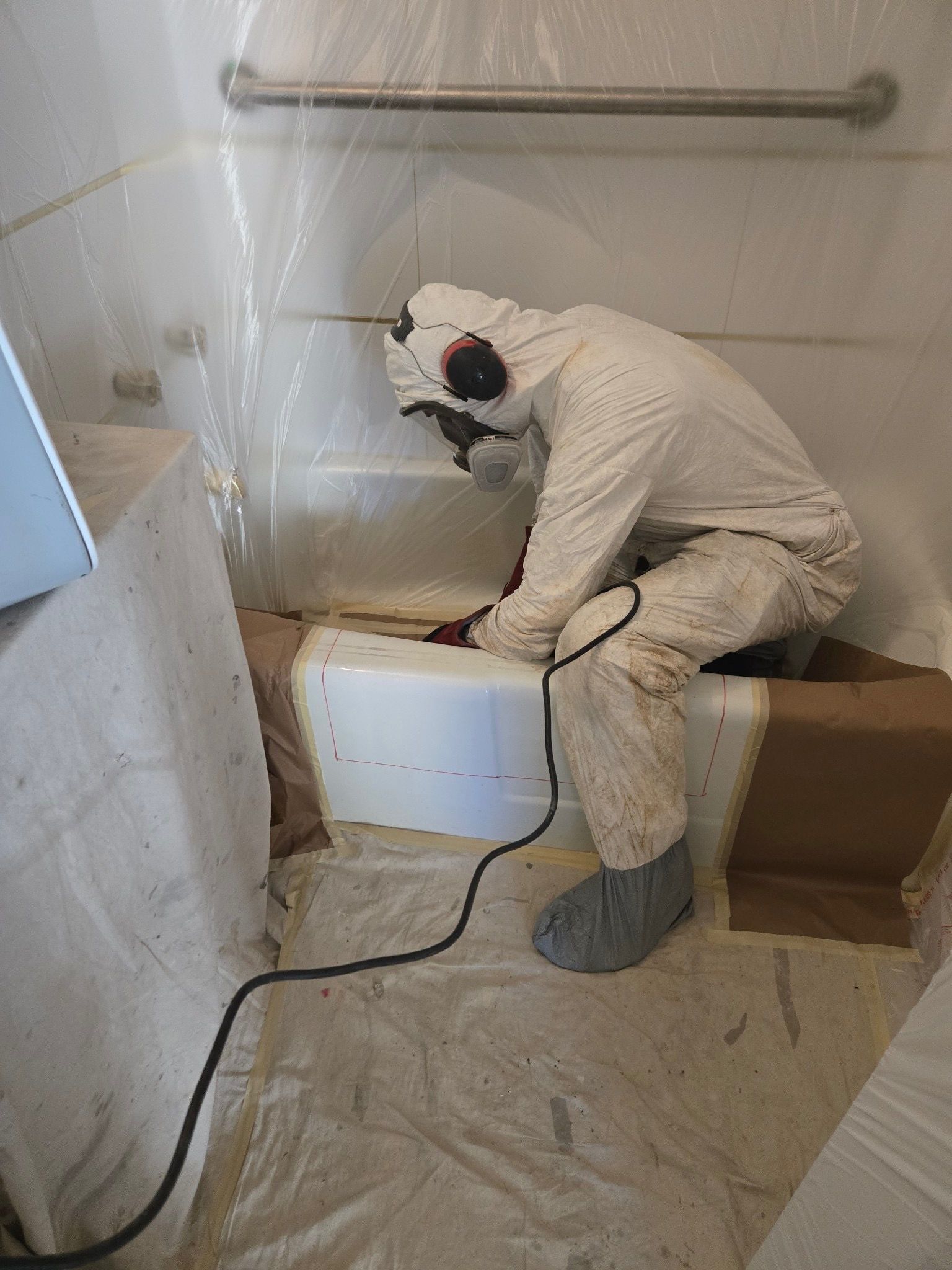 A bathtub is being painted in a bathroom.