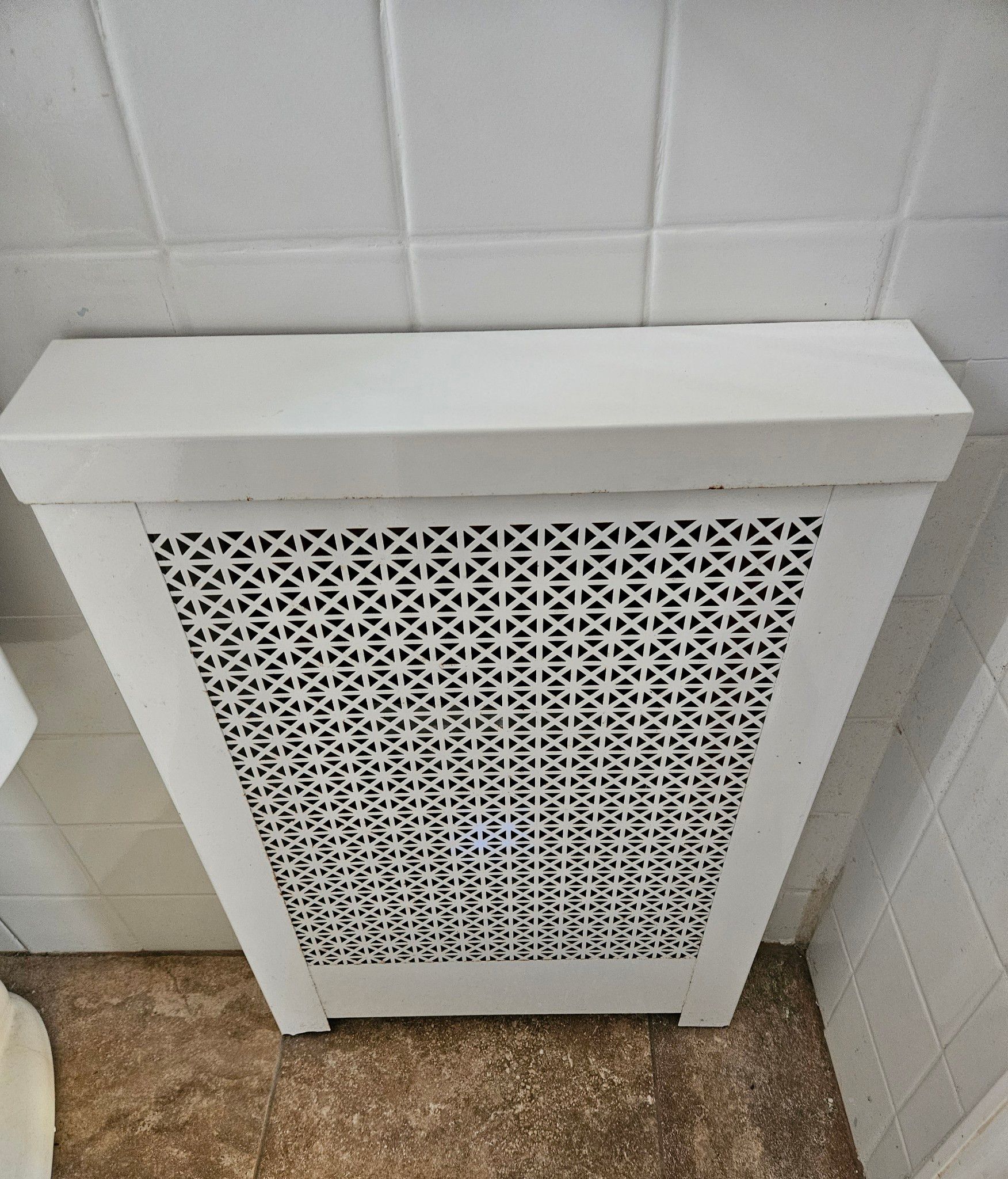 A black and white photo of a bathroom with a radiator and toilet.