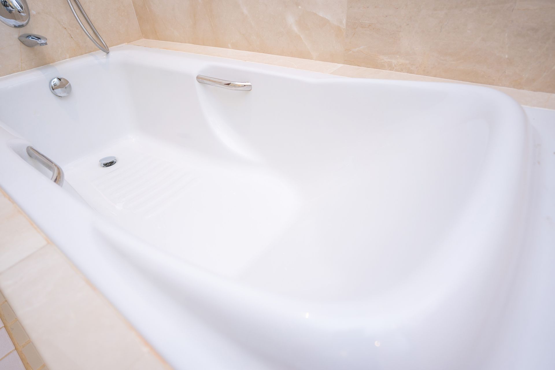 A white bathtub in a bathroom with a shower head.