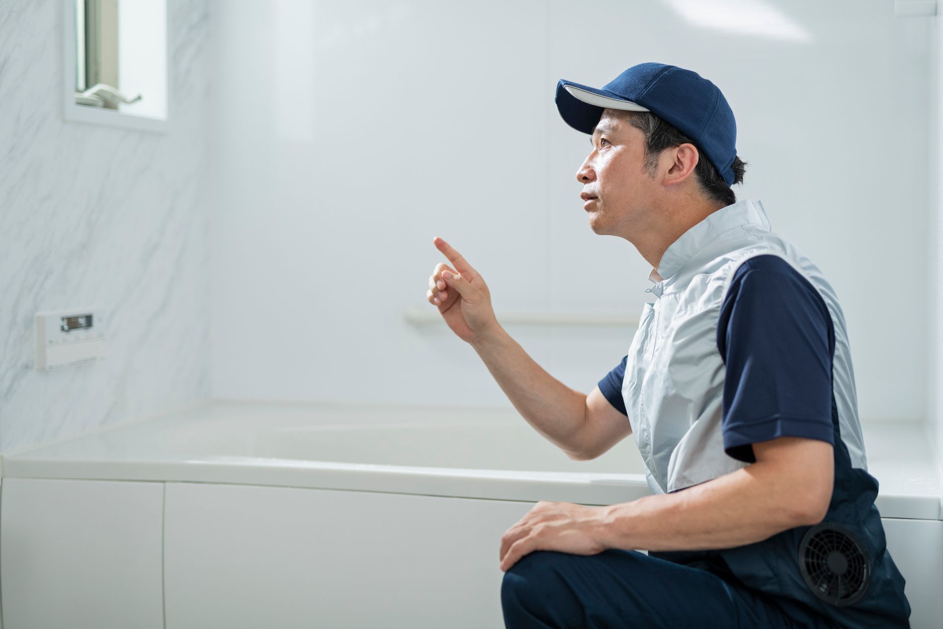 Professional technician reglazing a worn bathtub surface in a Montclair bathroom.