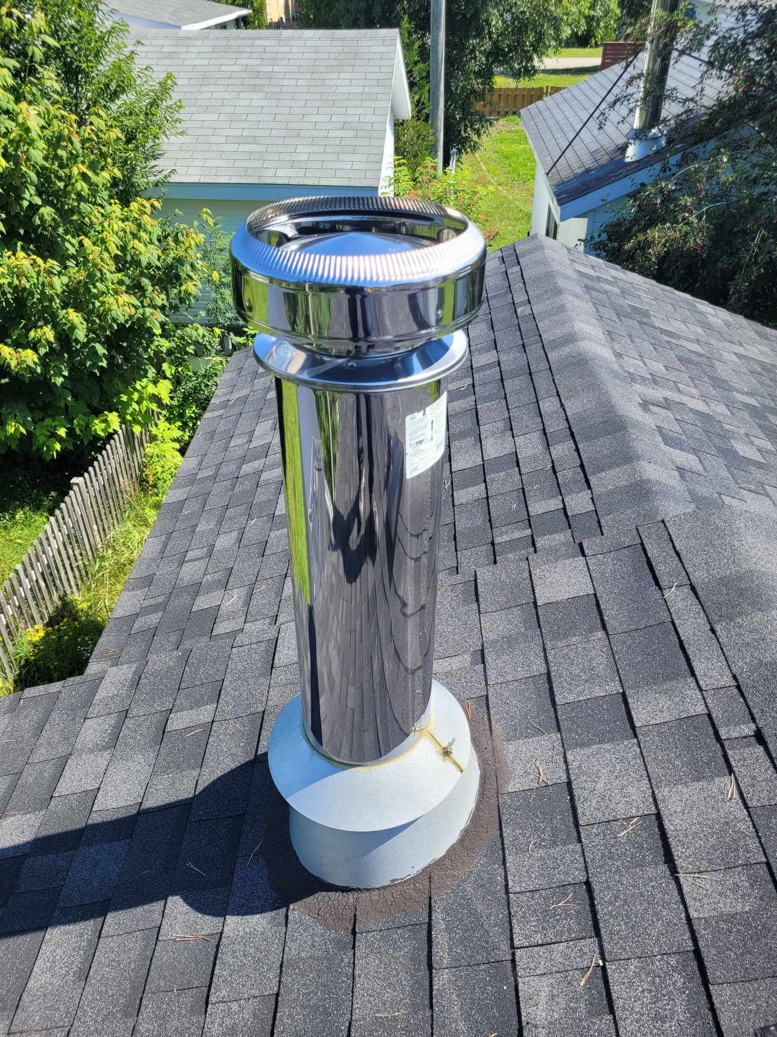 Une cheminée en acier inoxydable se trouve au sommet d'un toit.
