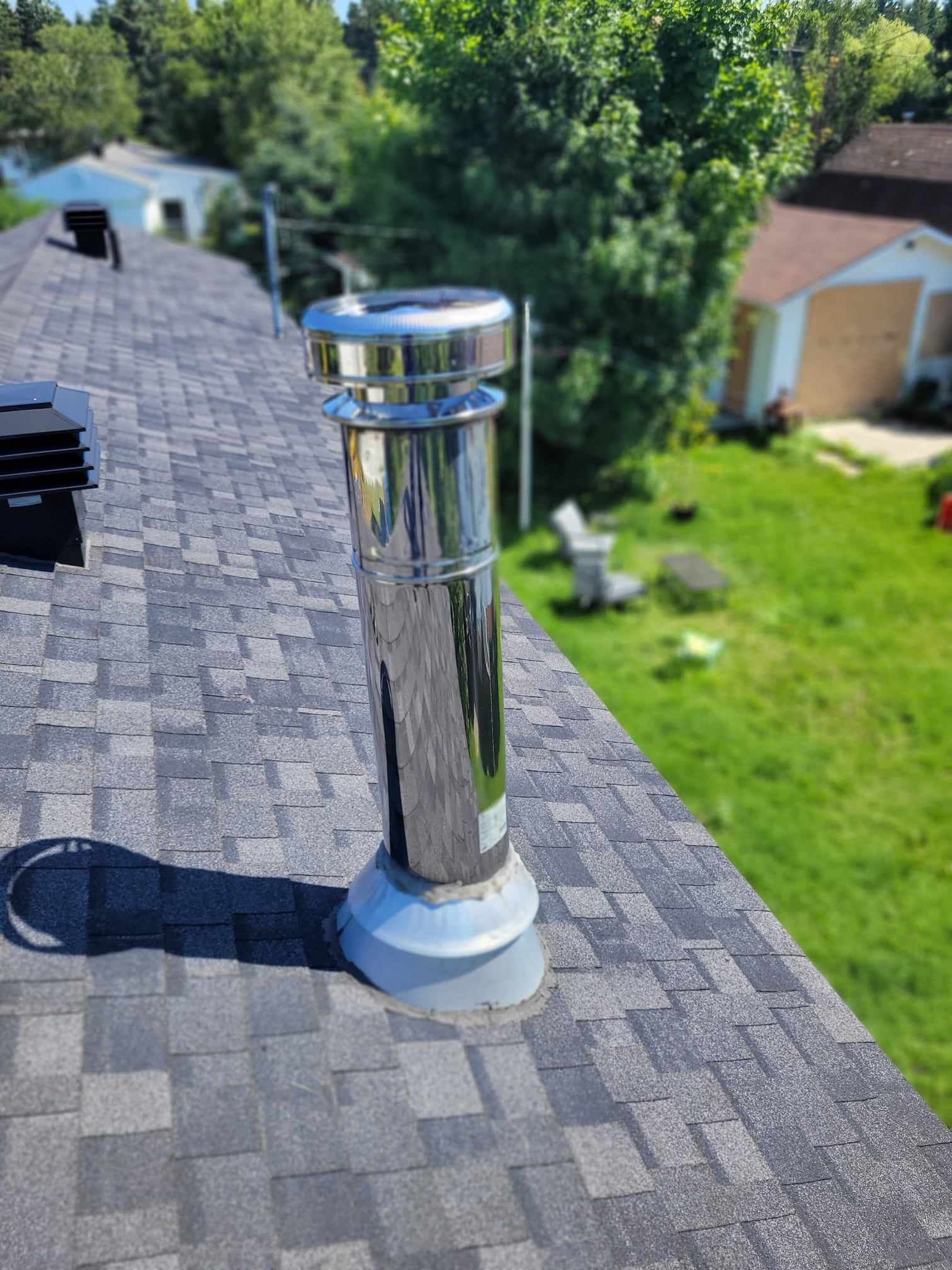 Une cheminée en acier inoxydable se trouve au sommet d'un toit.