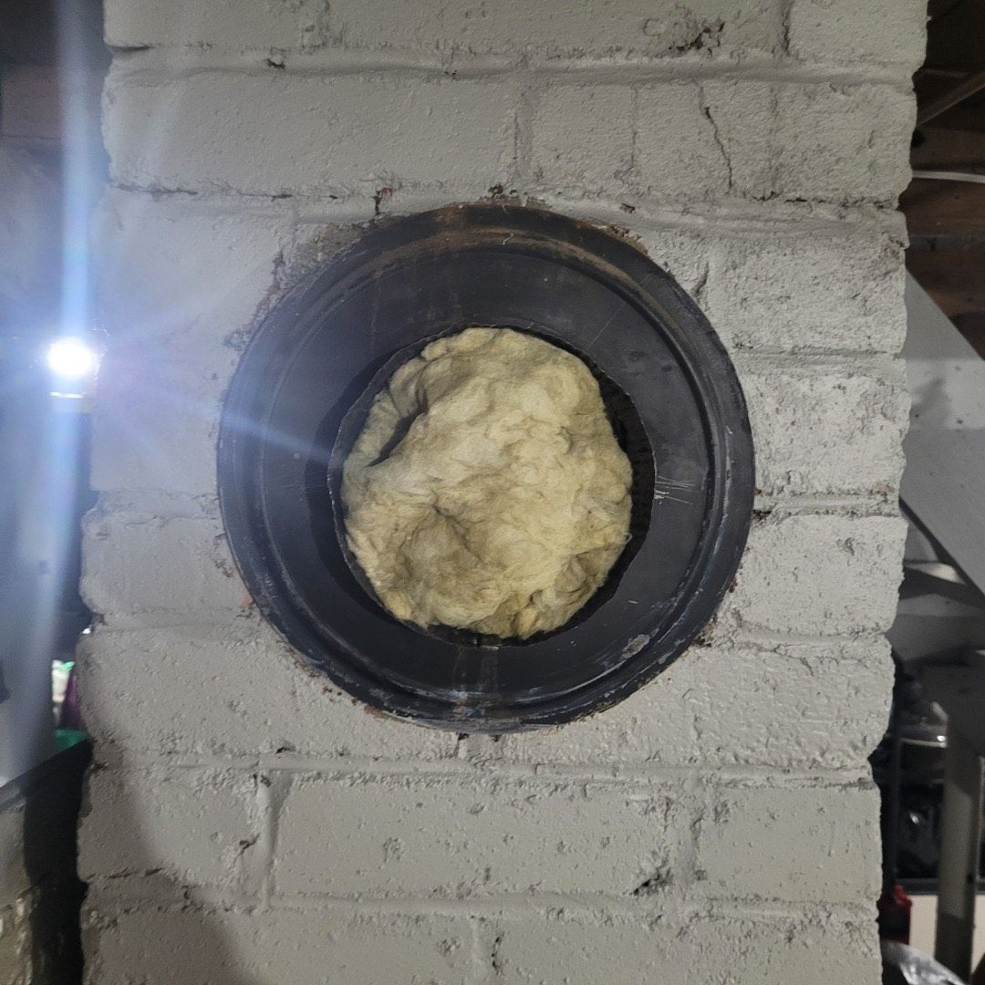 Un morceau de pâte dépasse d'un trou dans un mur de briques.