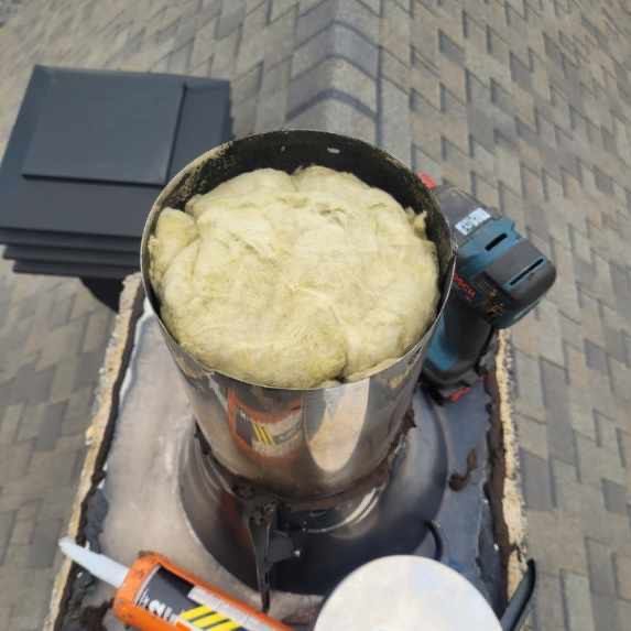 Un récipient en acier inoxydable rempli de mousse à côté d'une perceuse