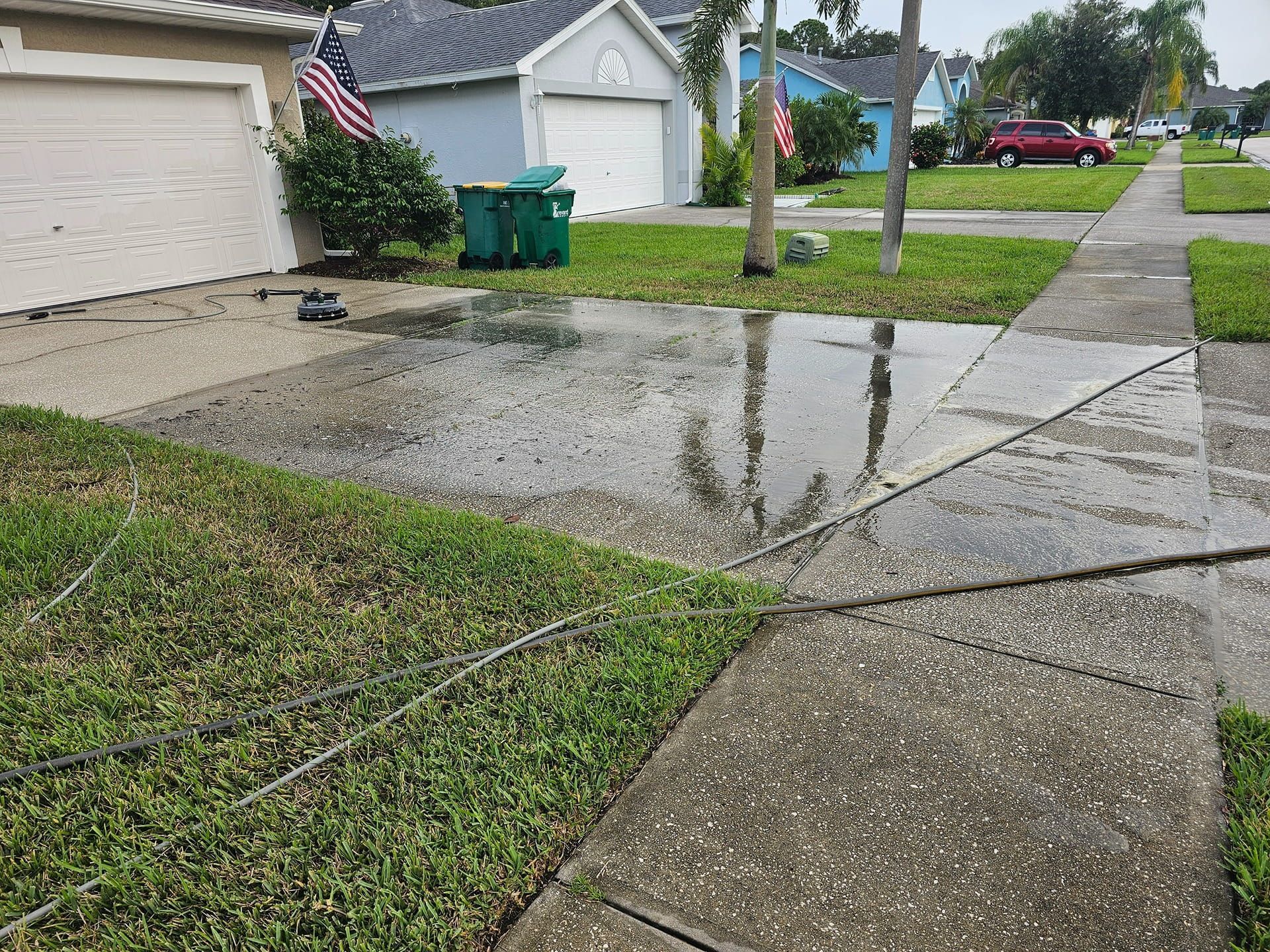 Woman in straw hat smiles, holding wine glass near a lake.