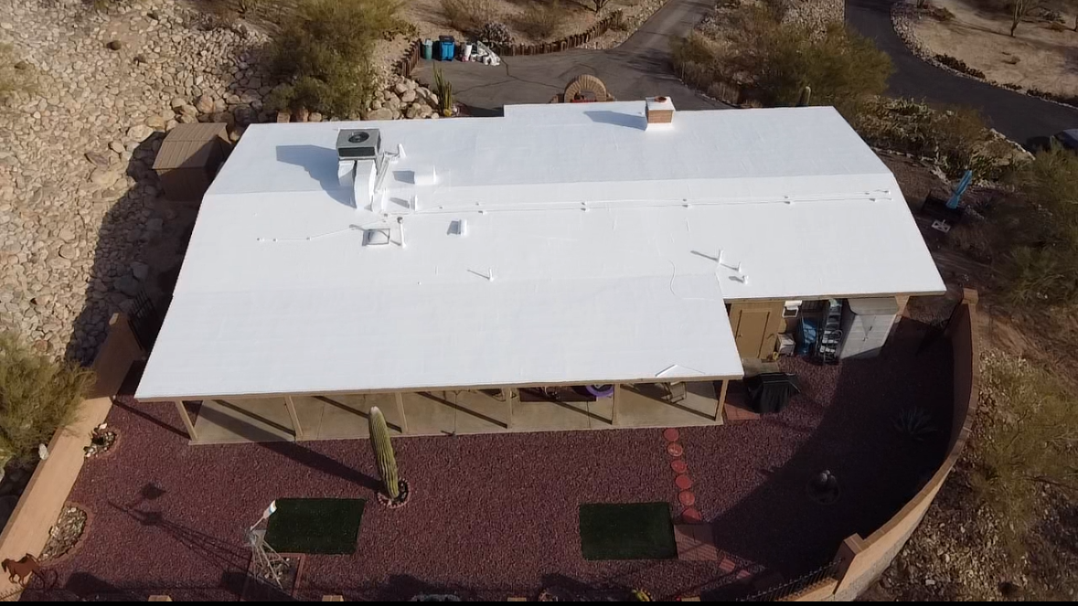 An aerial view of a house with a white roof.