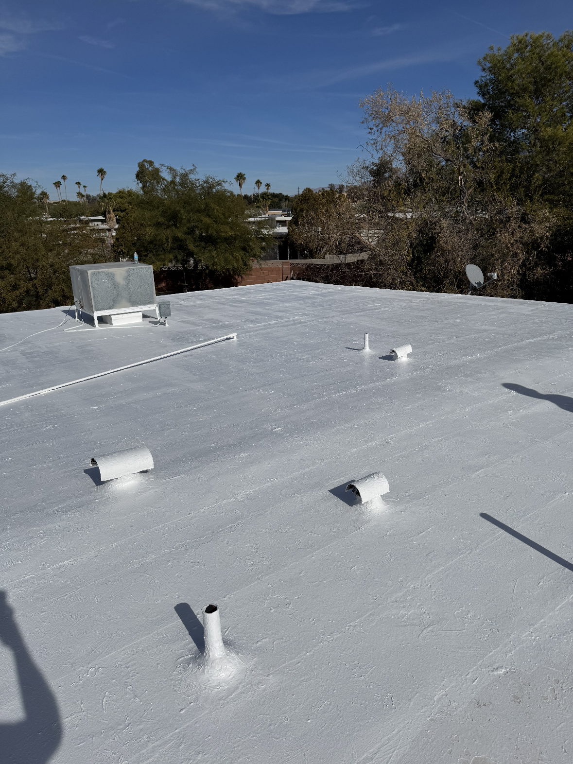 A white roof with a chimney on top of it.