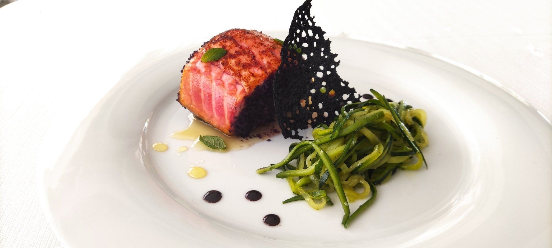 Un piatto bianco sormontato da un pezzo di carne e verdure.