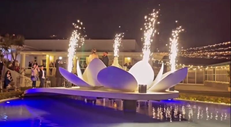 Un fiore di loto da cui escono fuochi d'artificio si trova al centro di una piscina.