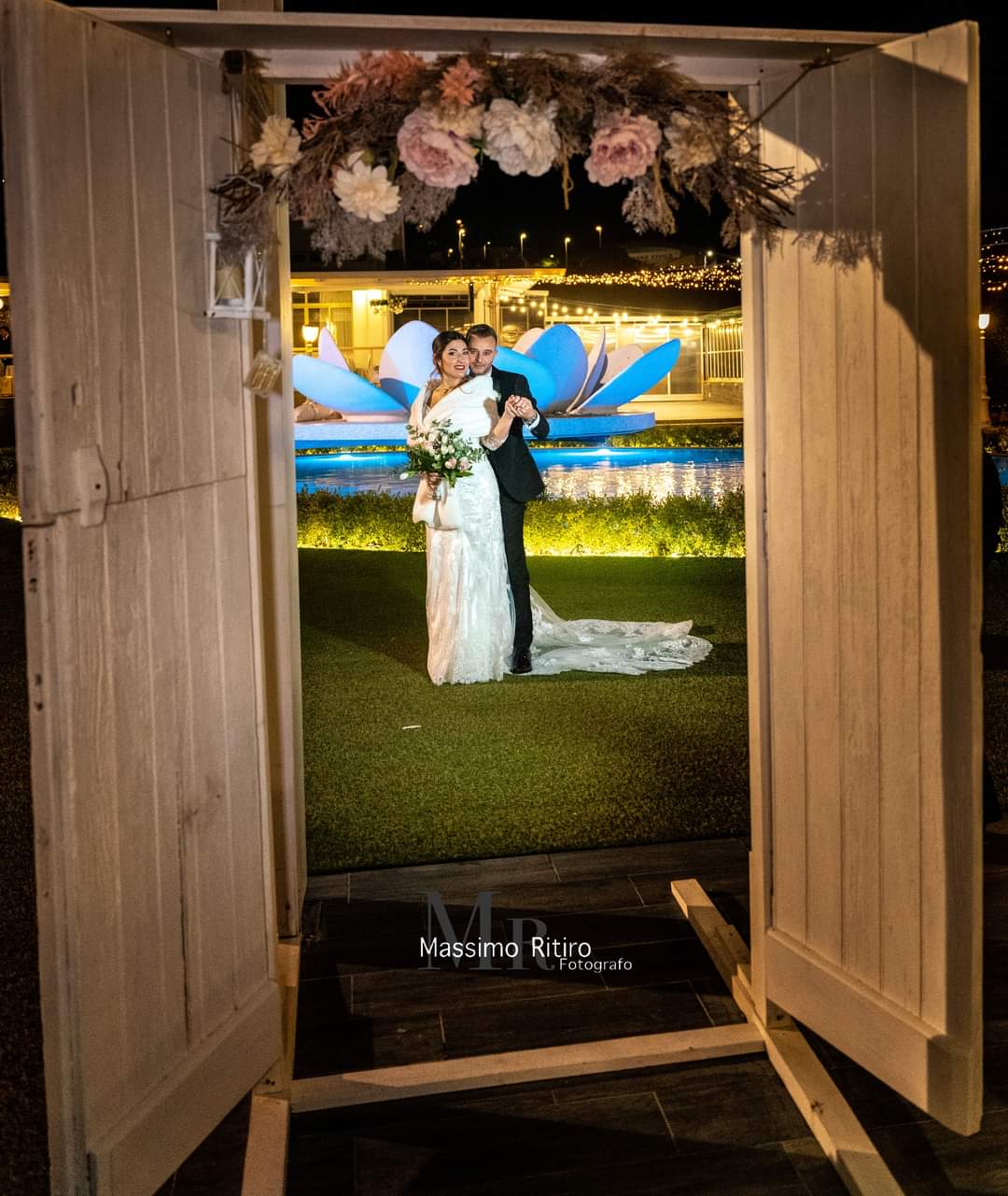 Una sposa e uno sposo sono in piedi davanti a una porta di legno