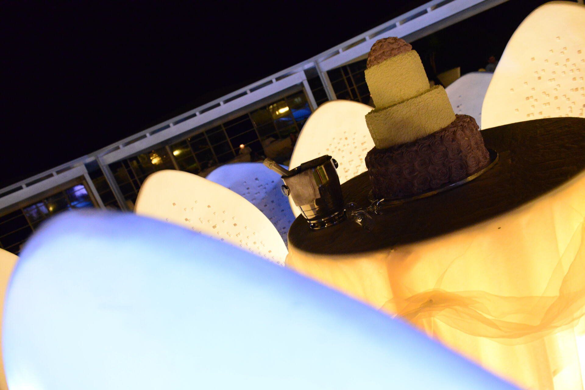 Una statua di una persona che indossa un cappello è illuminata di notte.