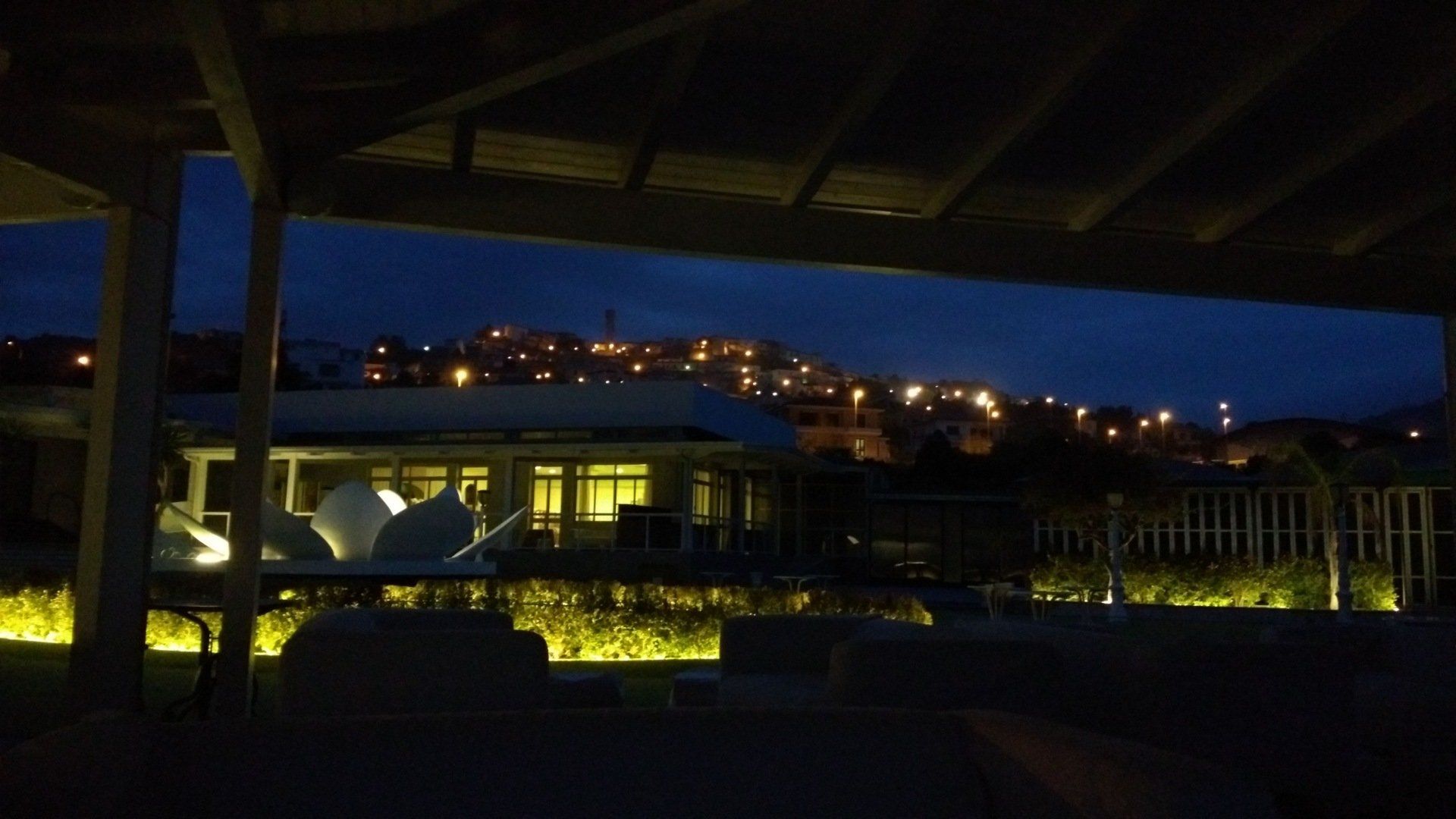 Una vista di una città di notte da un'area coperta