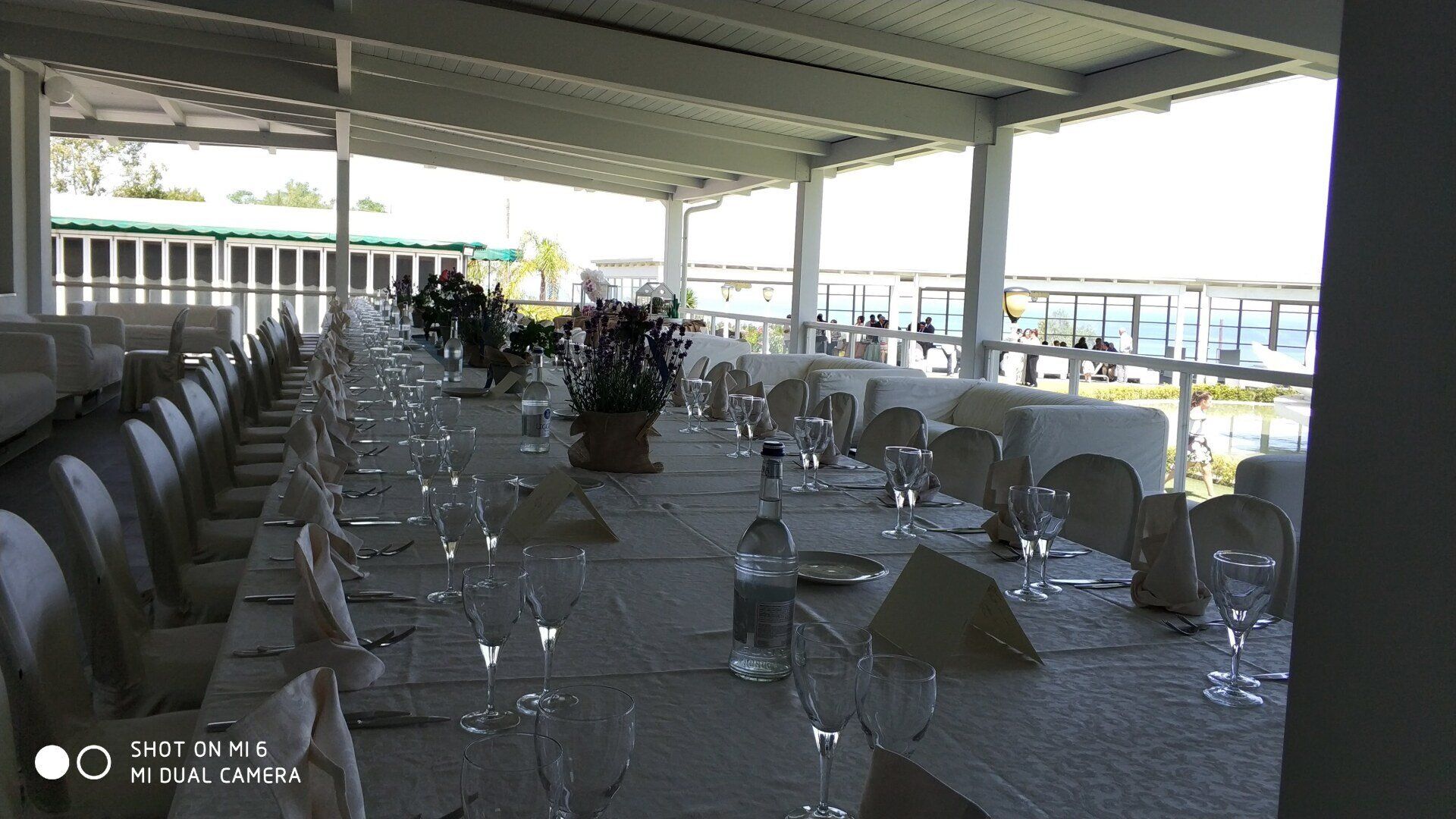 Un lungo tavolo con un sacco di bicchieri da vino sopra