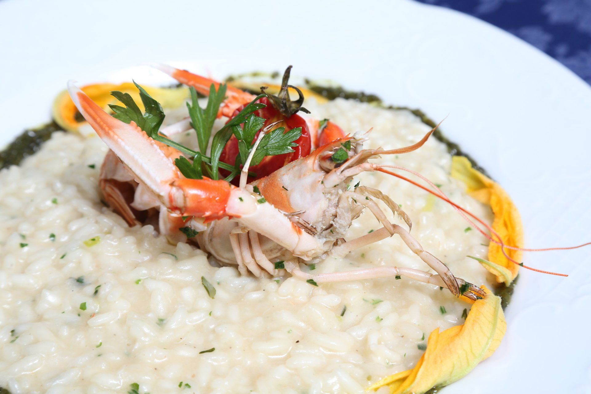 Un piatto di risotto con gamberi e pomodori sopra.