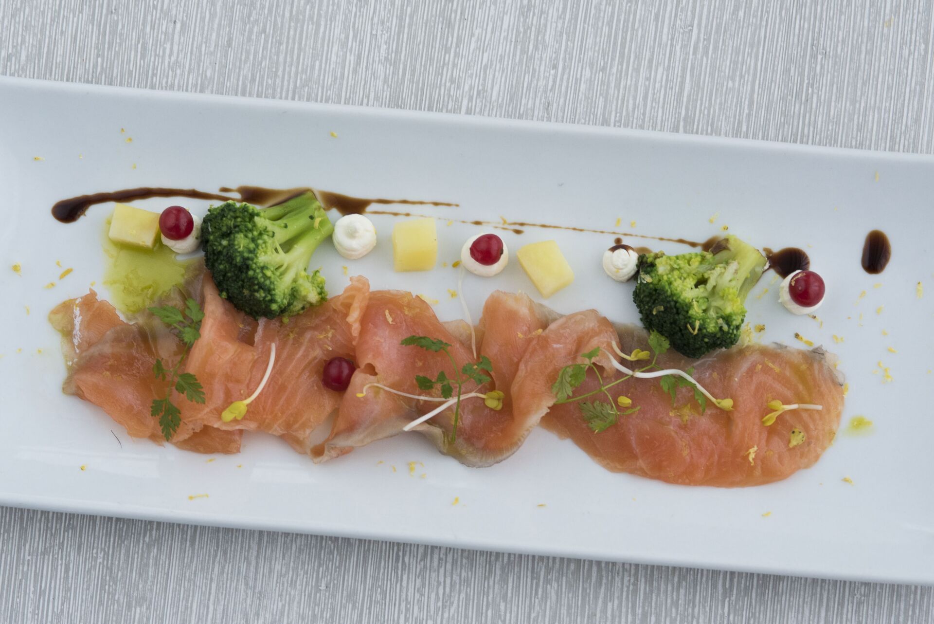 Un piatto bianco con sopra fette di salmone e broccoli