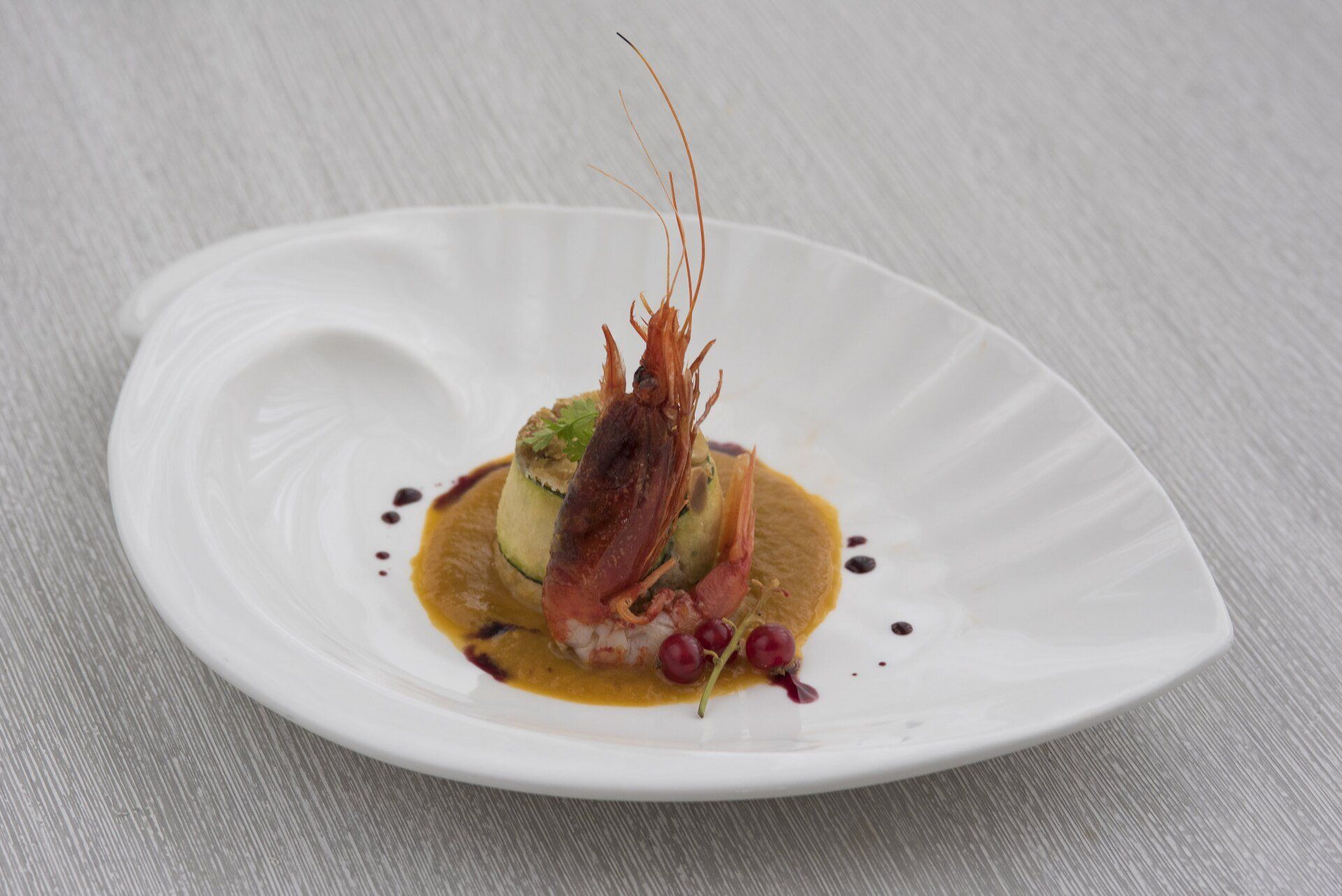 Un piatto bianco con un gambero sopra