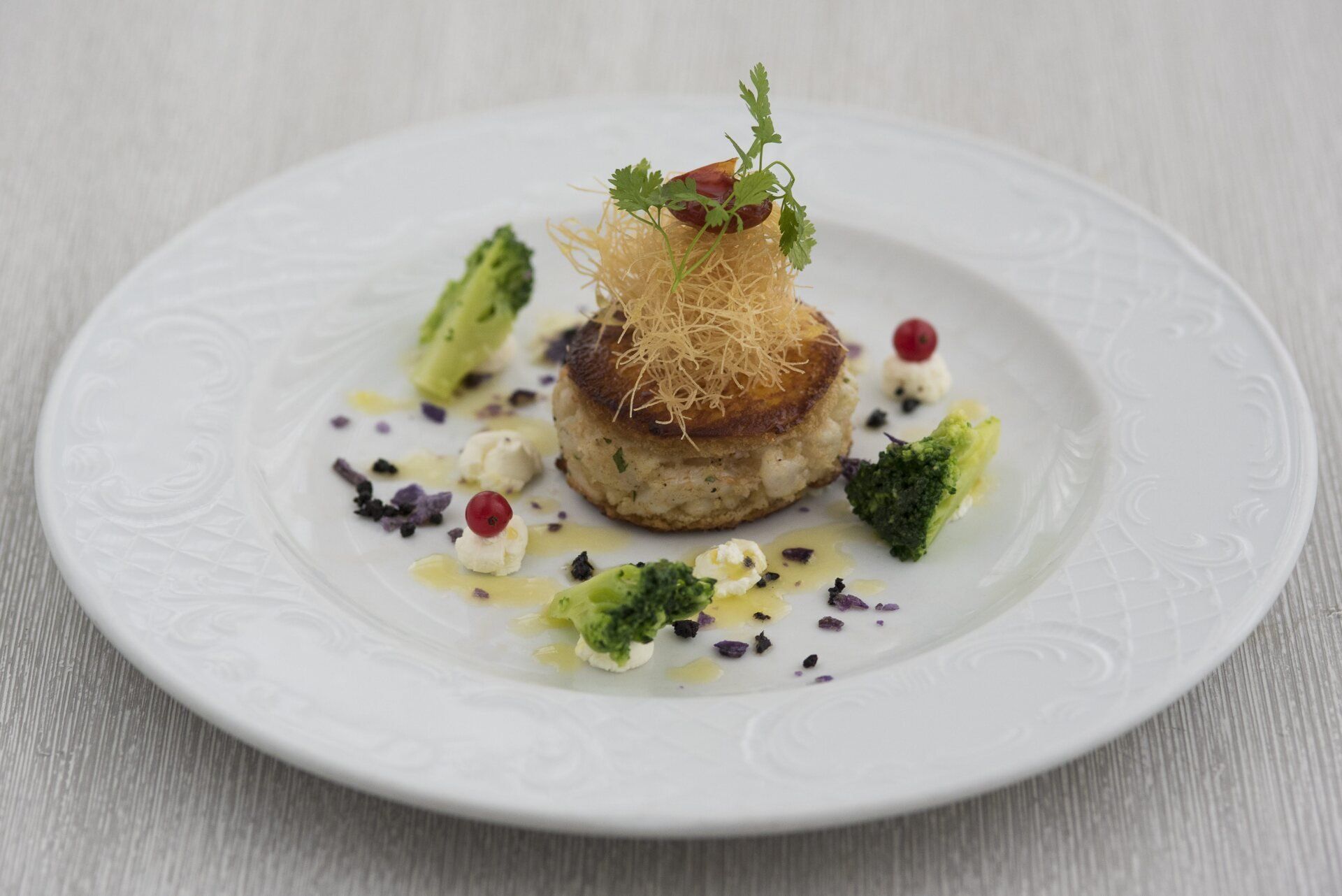 Un piatto bianco con sopra un pezzo di cibo e dei broccoli.