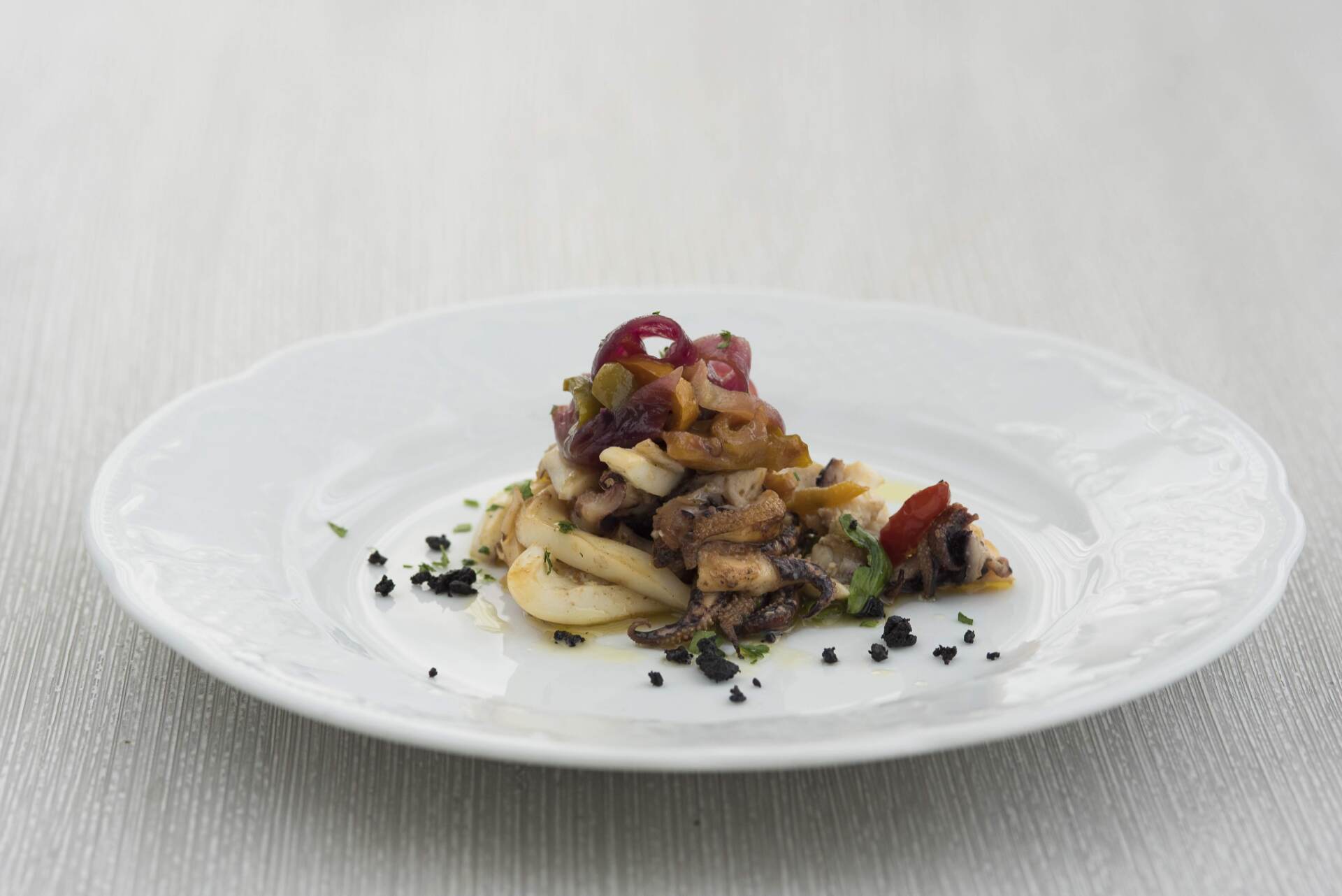 Un piatto bianco con sopra un'insalata di carne e verdure.