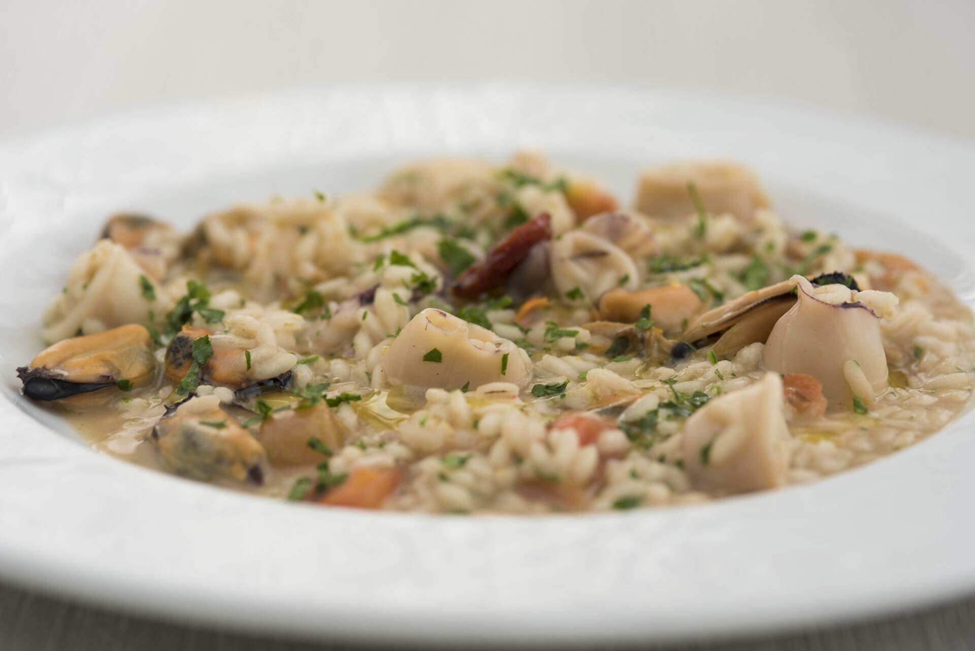 Un primo piano di una ciotola di risotto ai frutti di mare su un tavolo.