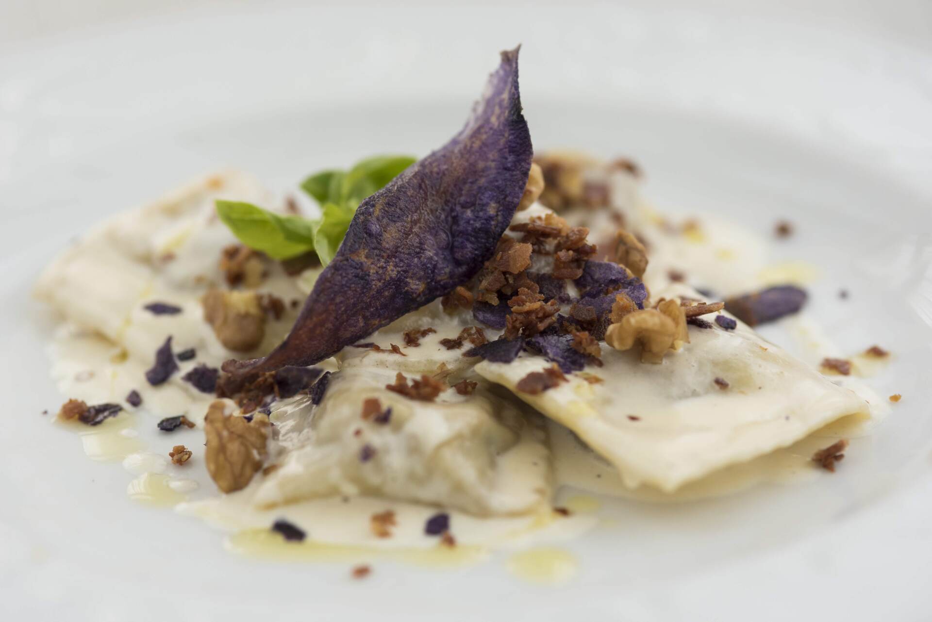 Un primo piano di un piatto di cibo con una foglia viola sopra.