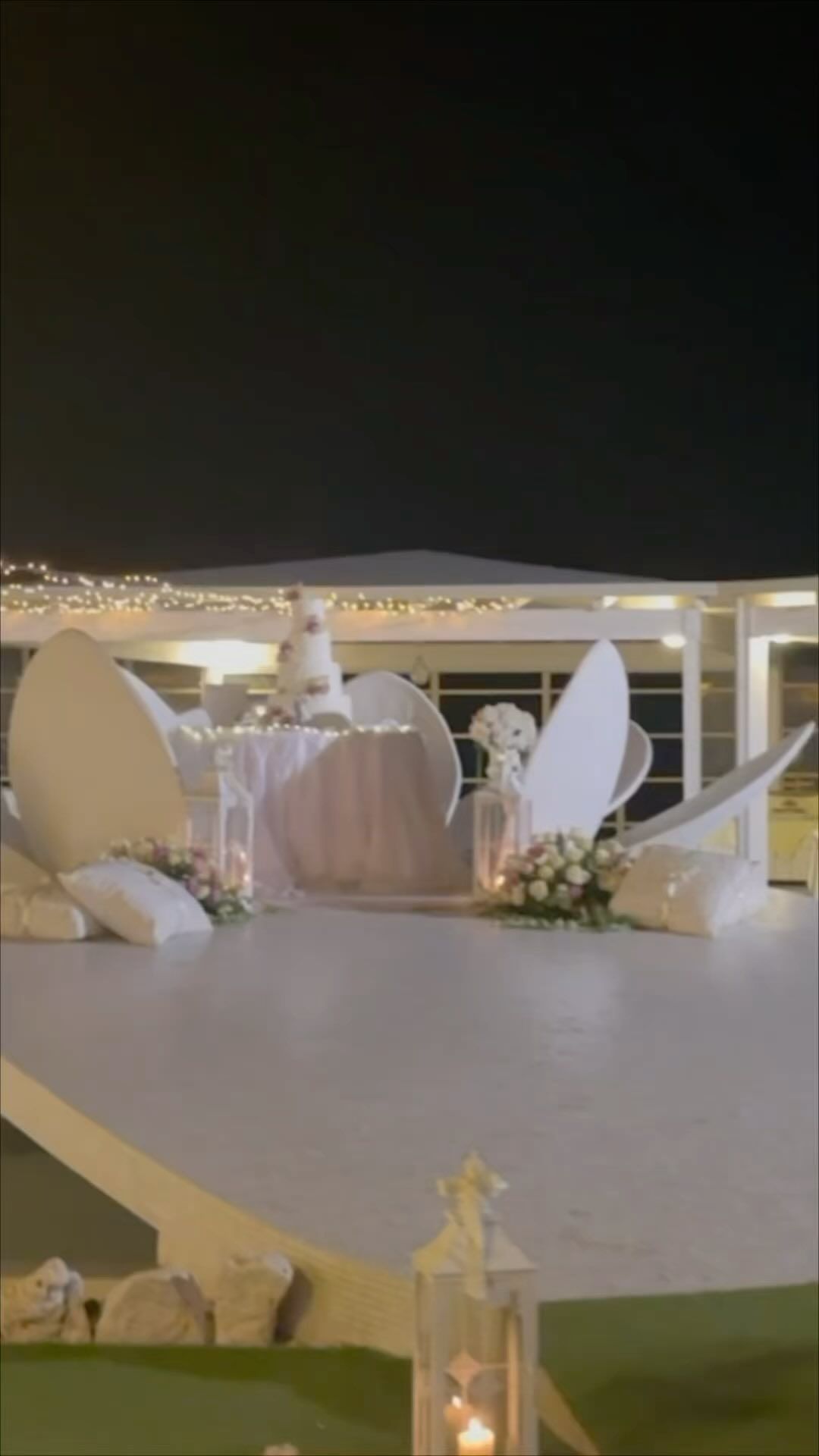 Una torta nuziale è appoggiata su un tavolo bianco.