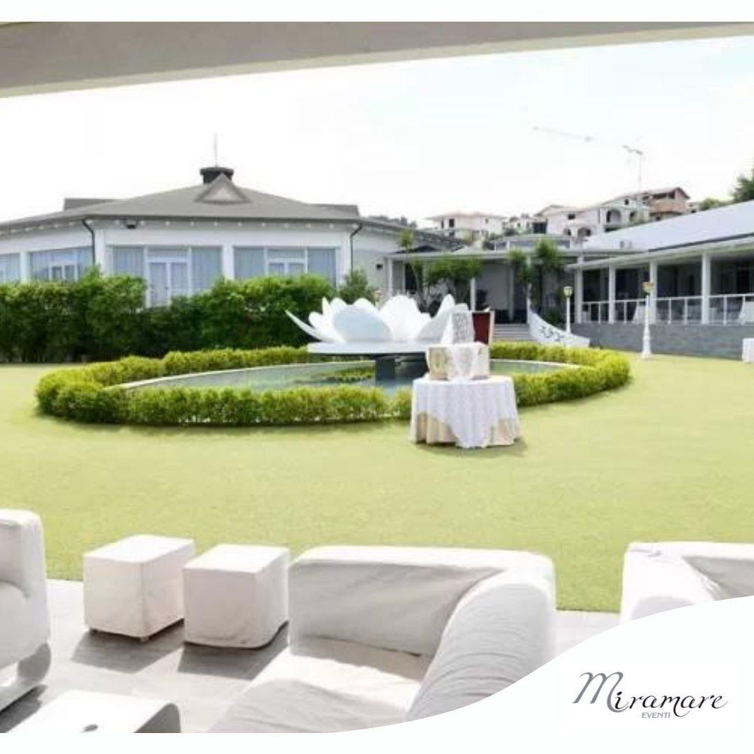 Un prato con un tavolo e delle sedie al centro