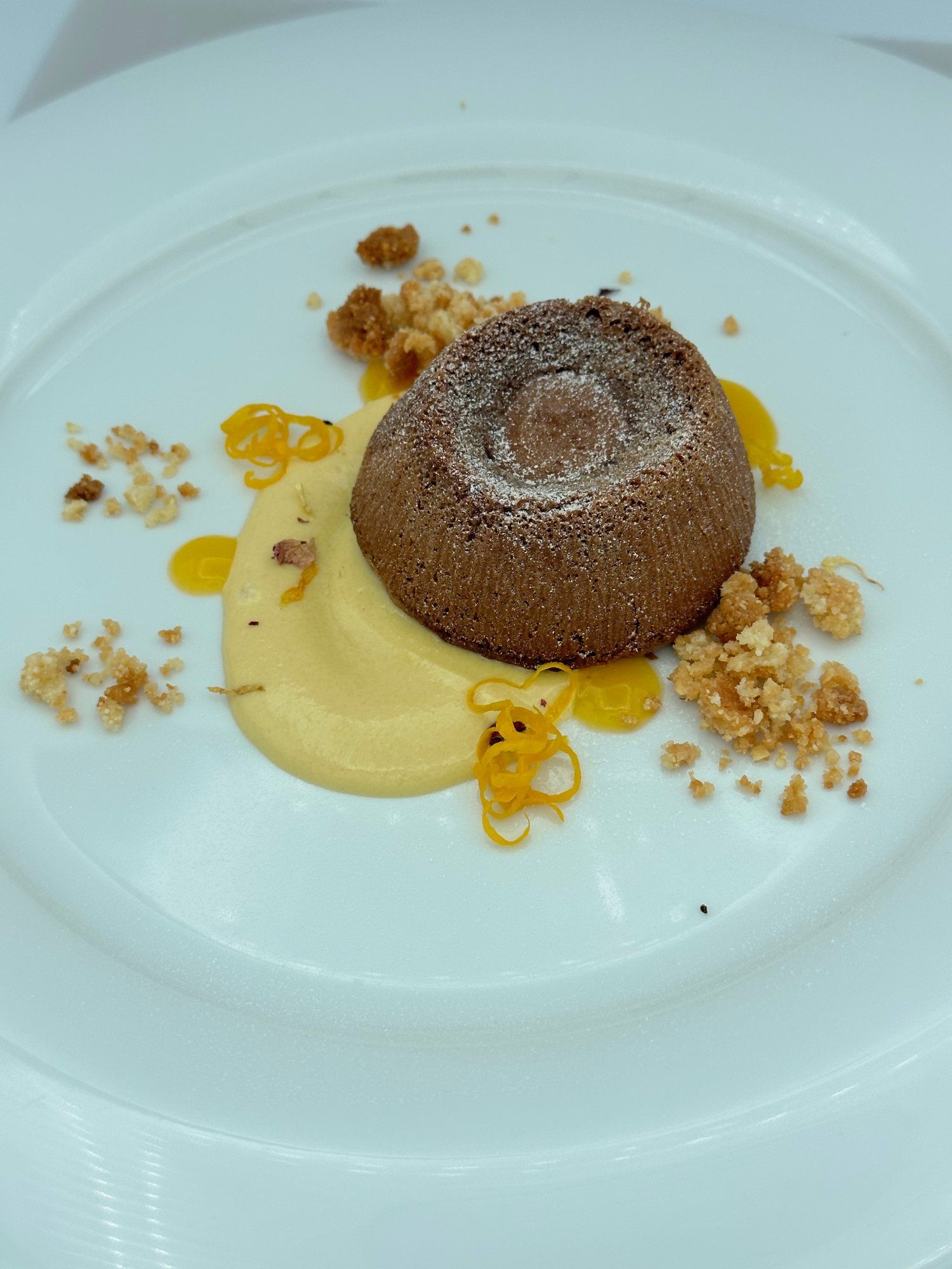 Un piatto bianco sormontato da un dessert al cioccolato e noci