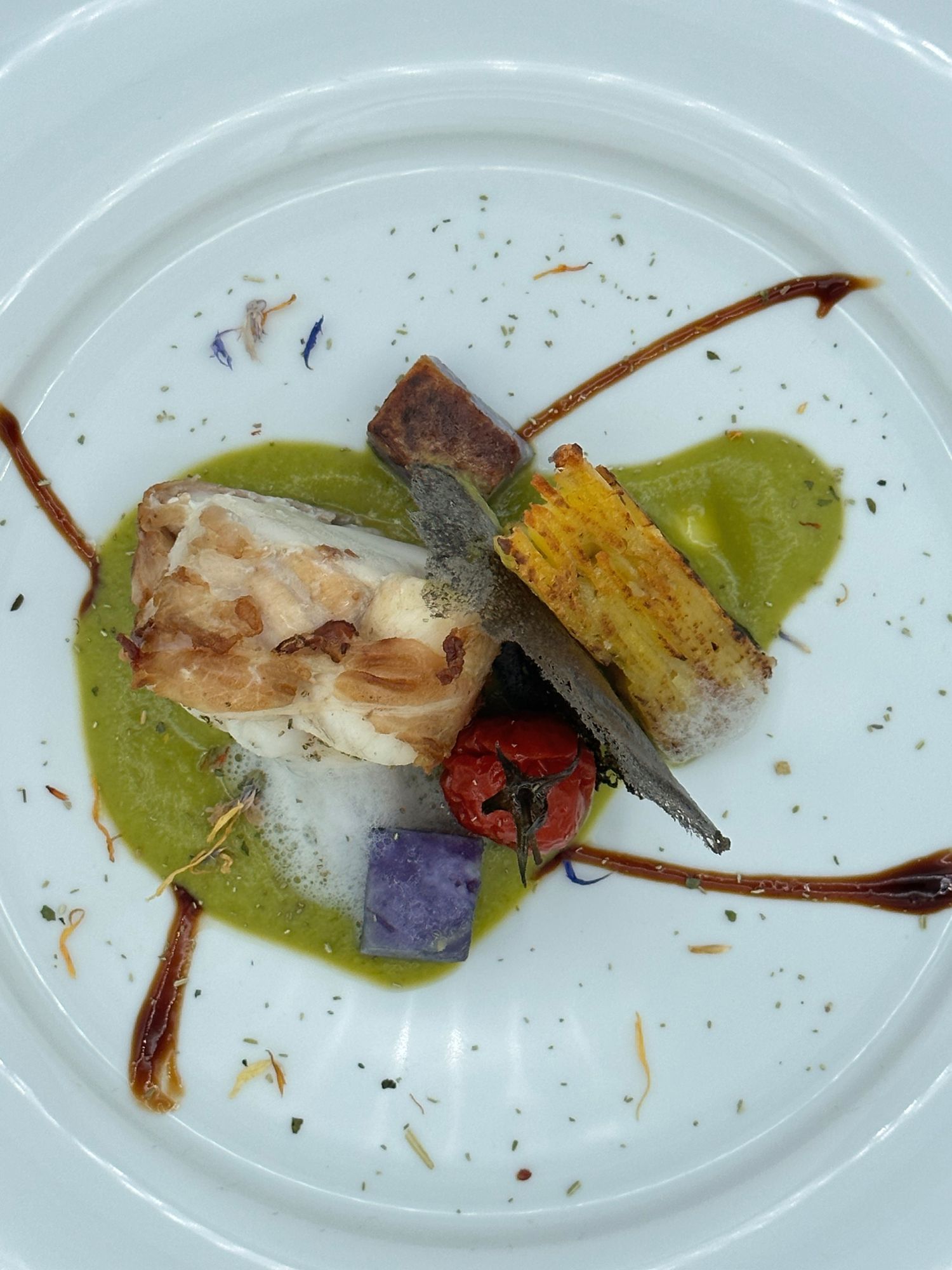 Un piatto bianco sormontato da un pezzo di carne e verdure