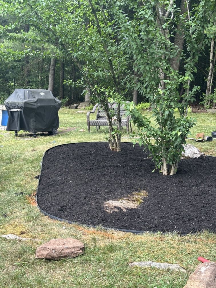 Two electricians working on an electrical panel outside a building. One holds a cable.