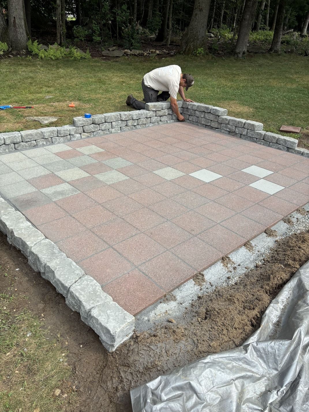 Gravel path winding through a park with trees, grass, and shrubs. Bright blue sky.
