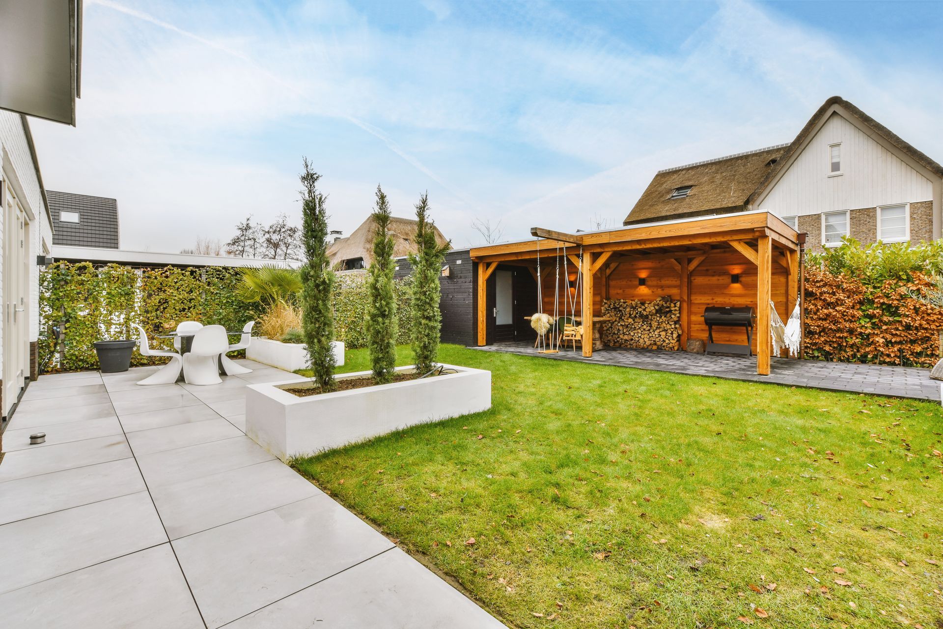 A house with a large lawn and a pergola in the backyard.