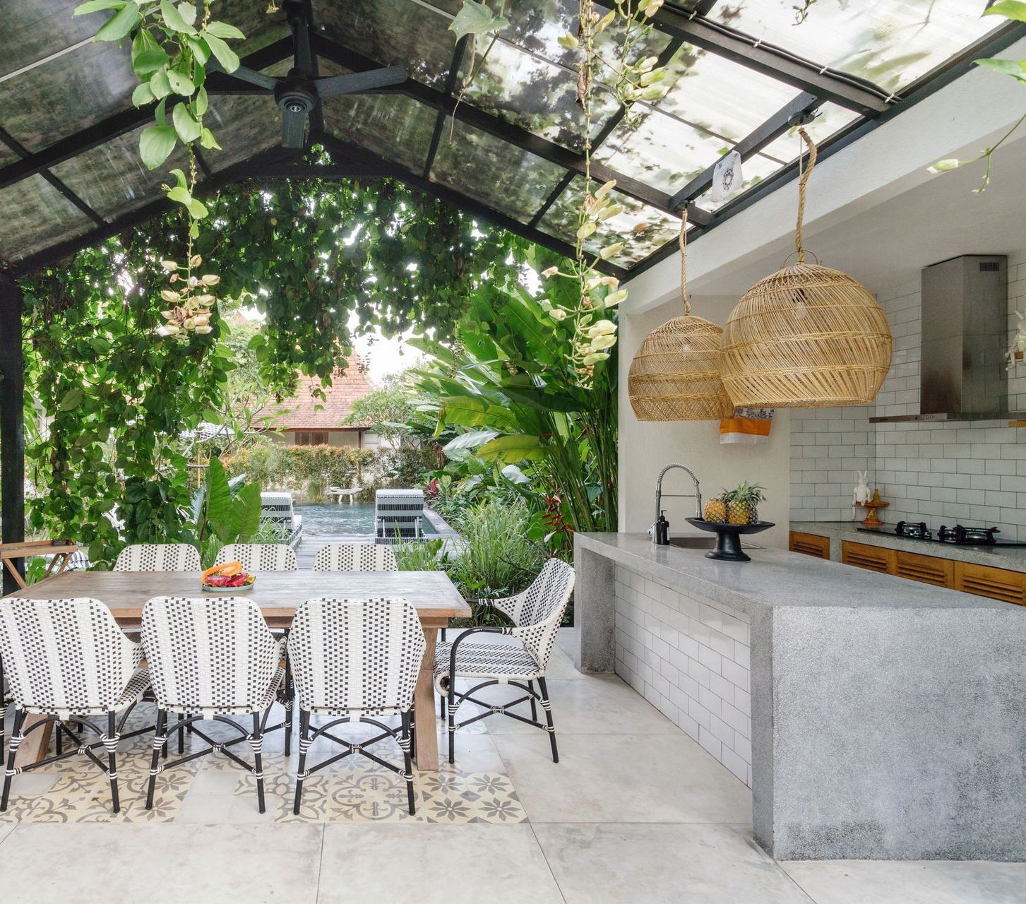 A kitchen with a table and chairs under a glass roof.