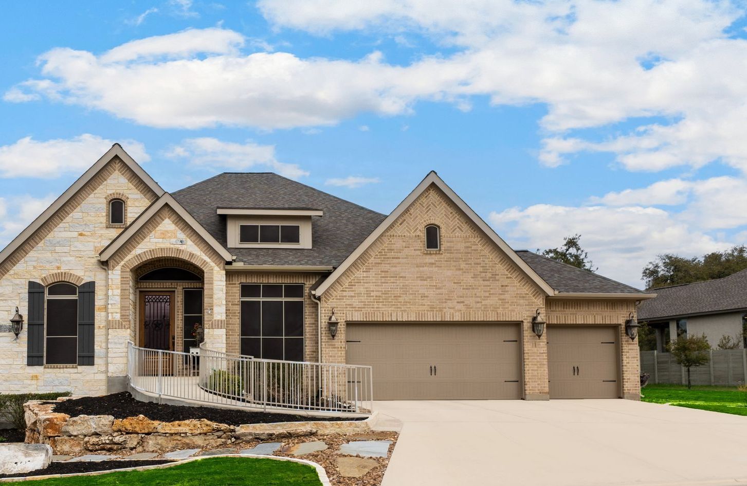 A large brick house with two garages and a driveway.