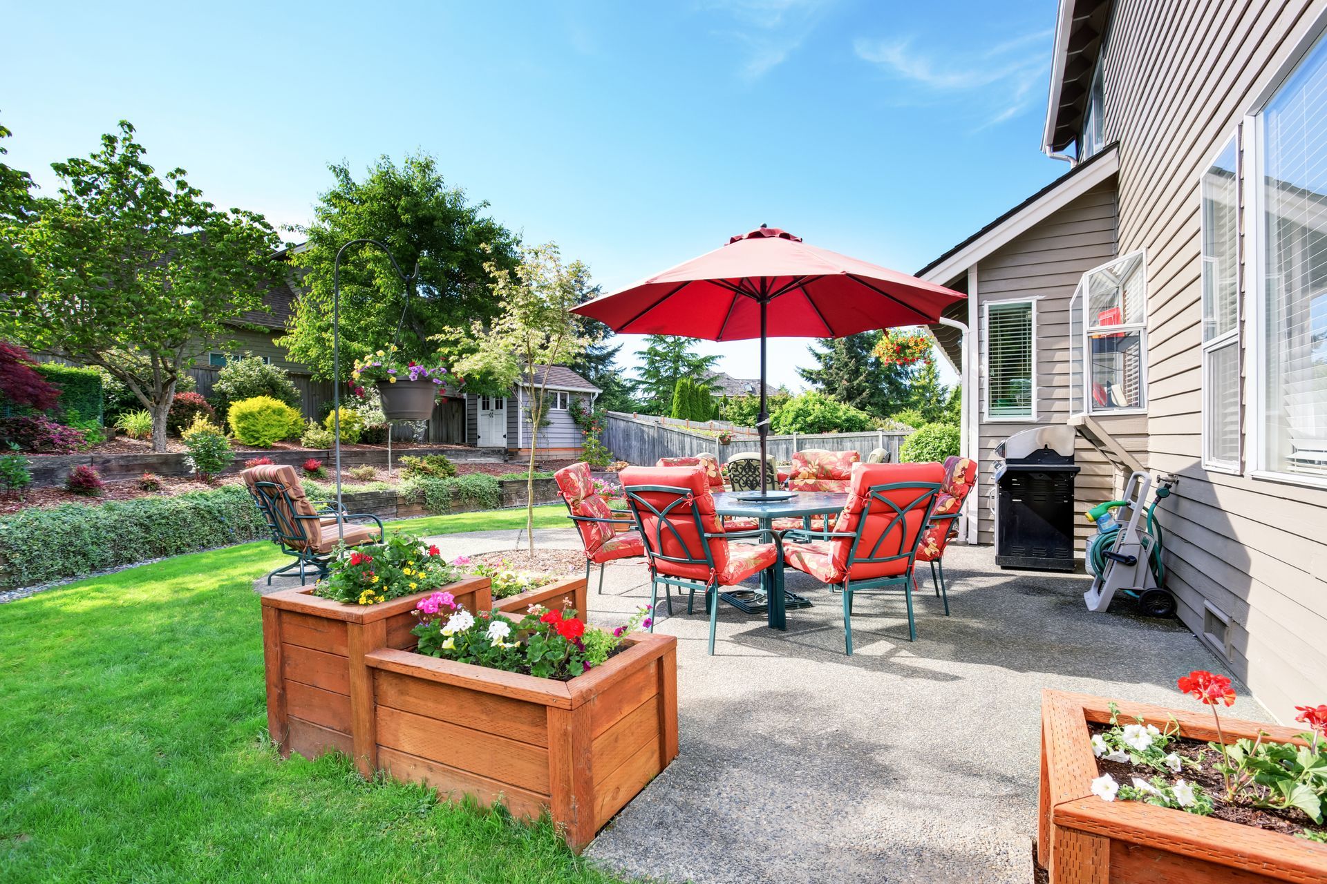 There is a patio with a table and chairs and an umbrella.