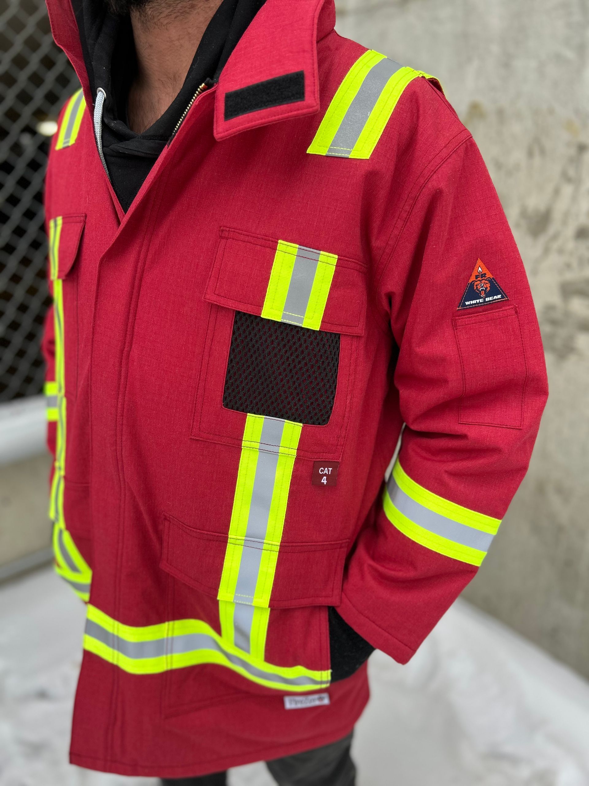 Red work jacket with reflective stripes and patches.