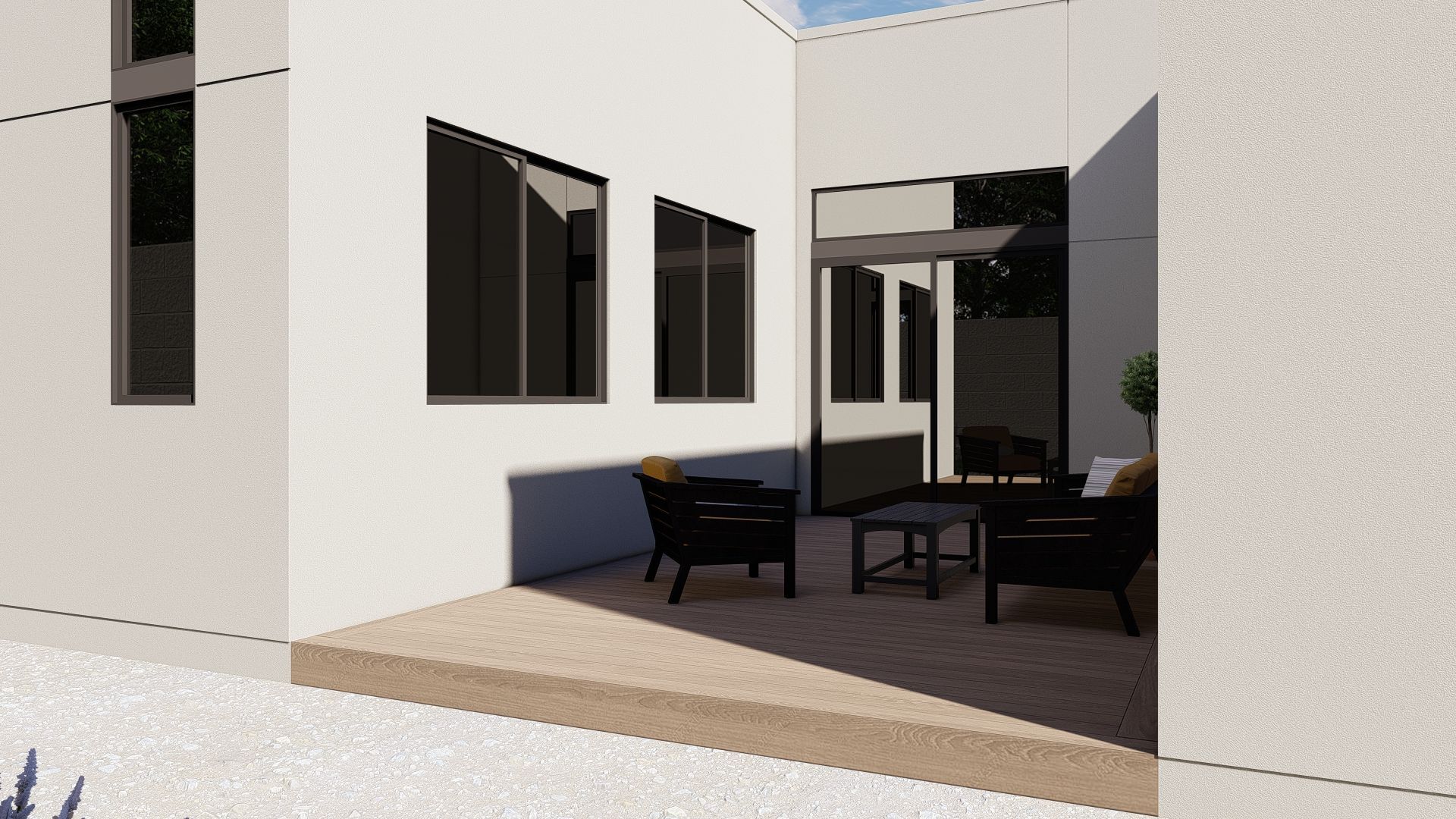 Exterior patio with seating, featuring a dark table and chairs, set against white walls and windows.