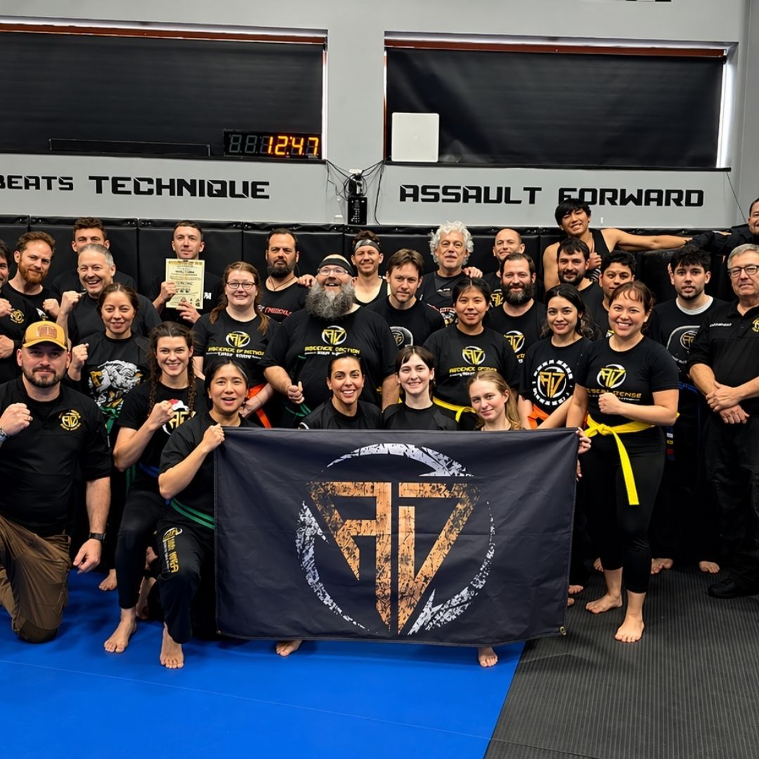 Five people in jiu-jitsu gear pose together in a gym.  Smiling,  some have arms around each other. Machado logo visible.