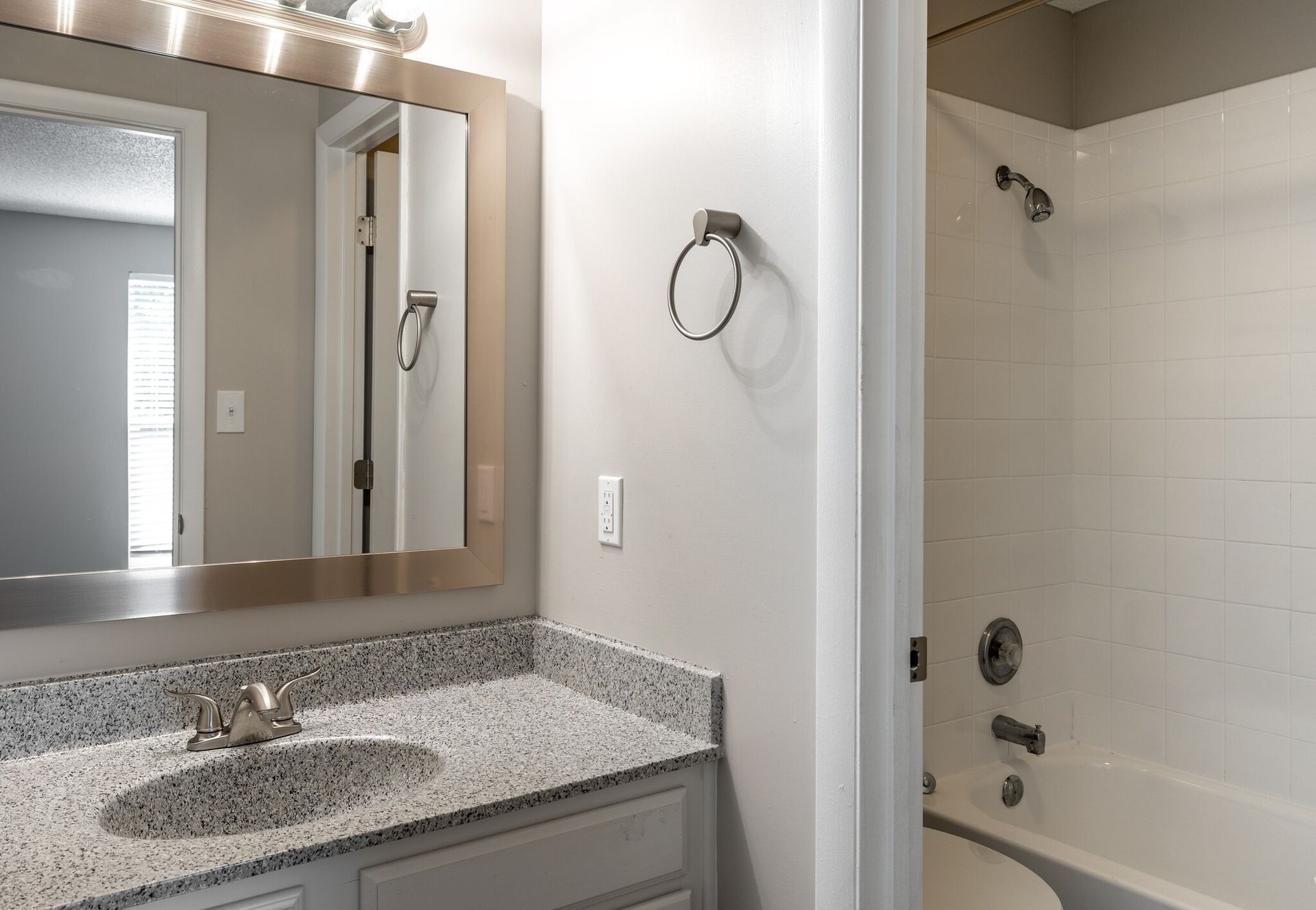 A bathroom with a sink , mirror and bathtub.