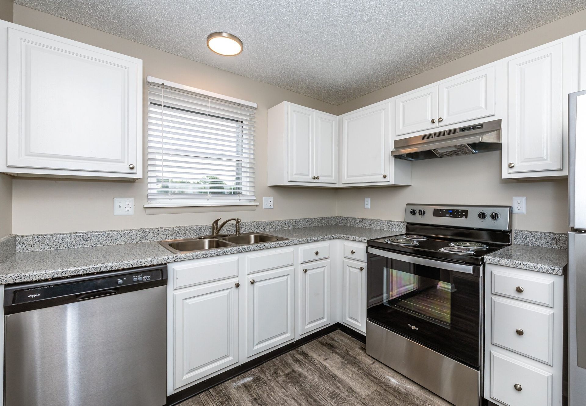A kitchen with white cabinets and stainless steel appliances