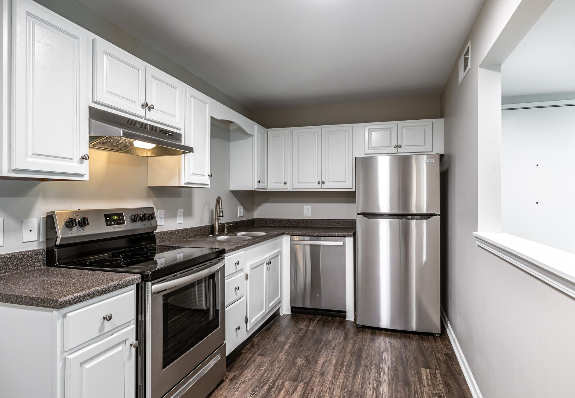 A kitchen with stainless steel appliances and white cabinets.
