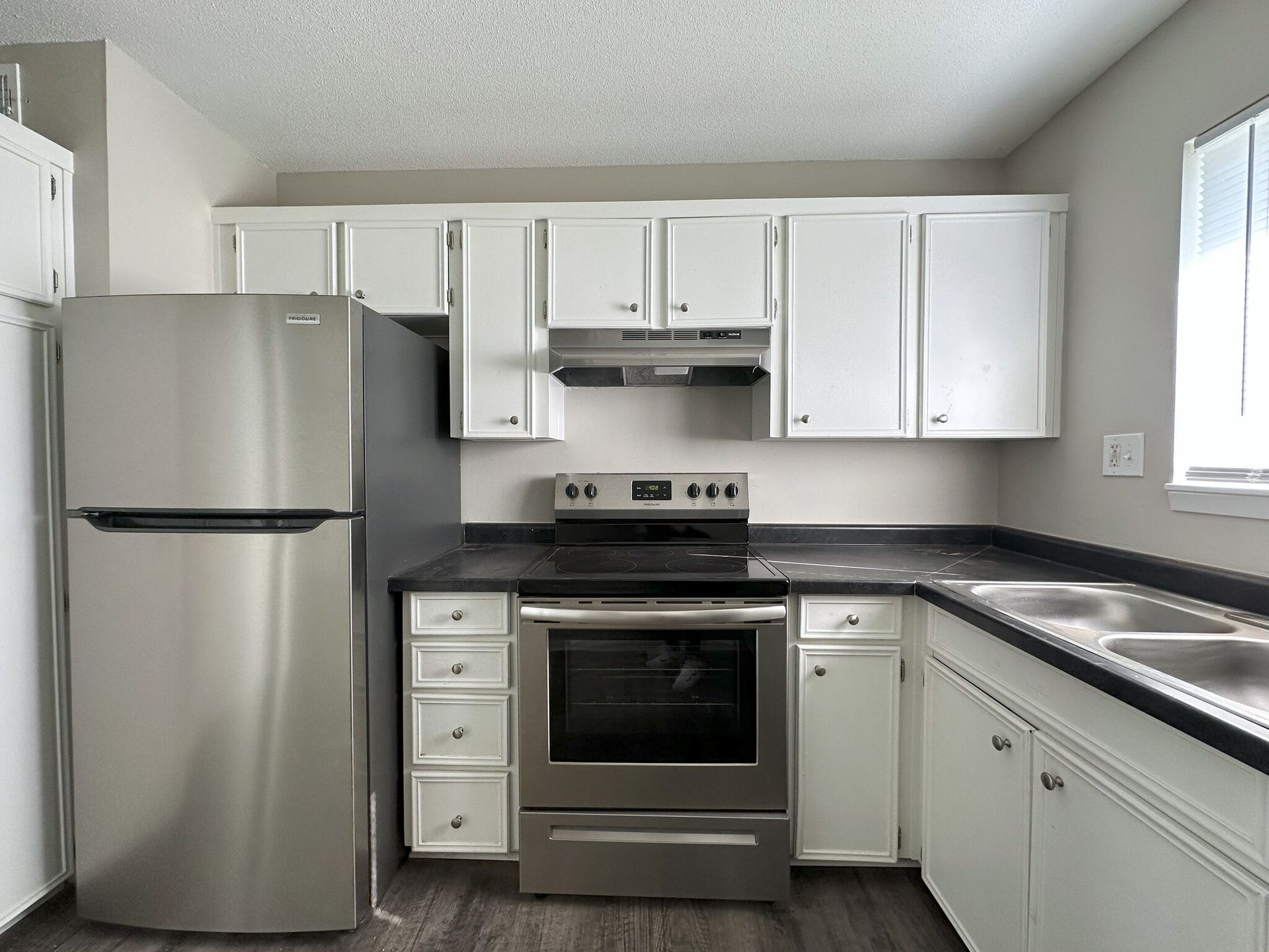 A kitchen with stainless steel appliances and white cabinets