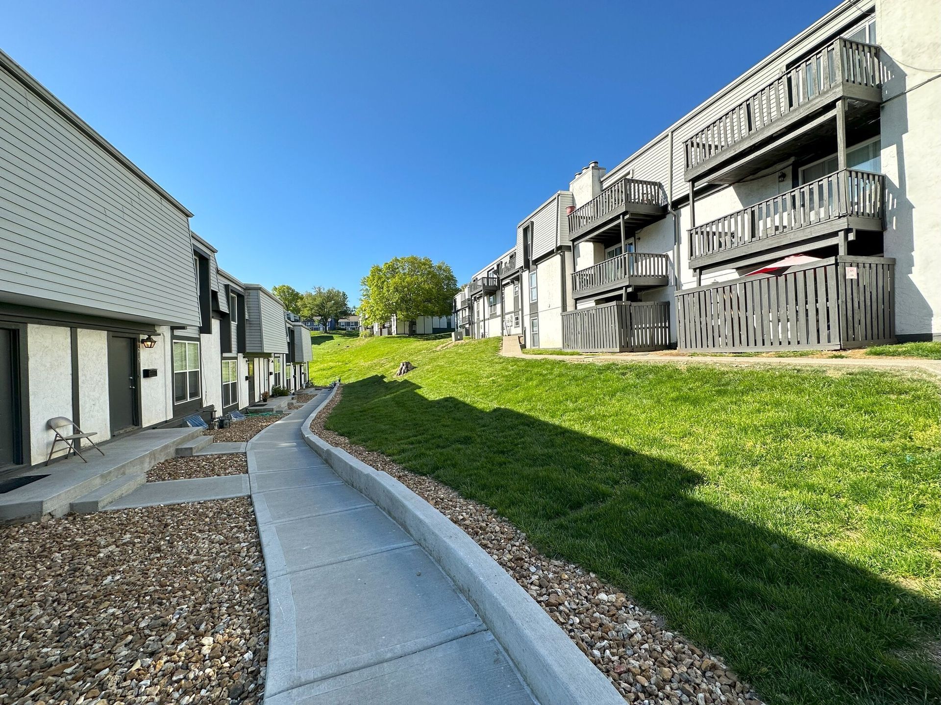 A row of apartment buildings with a walkway leading to them.