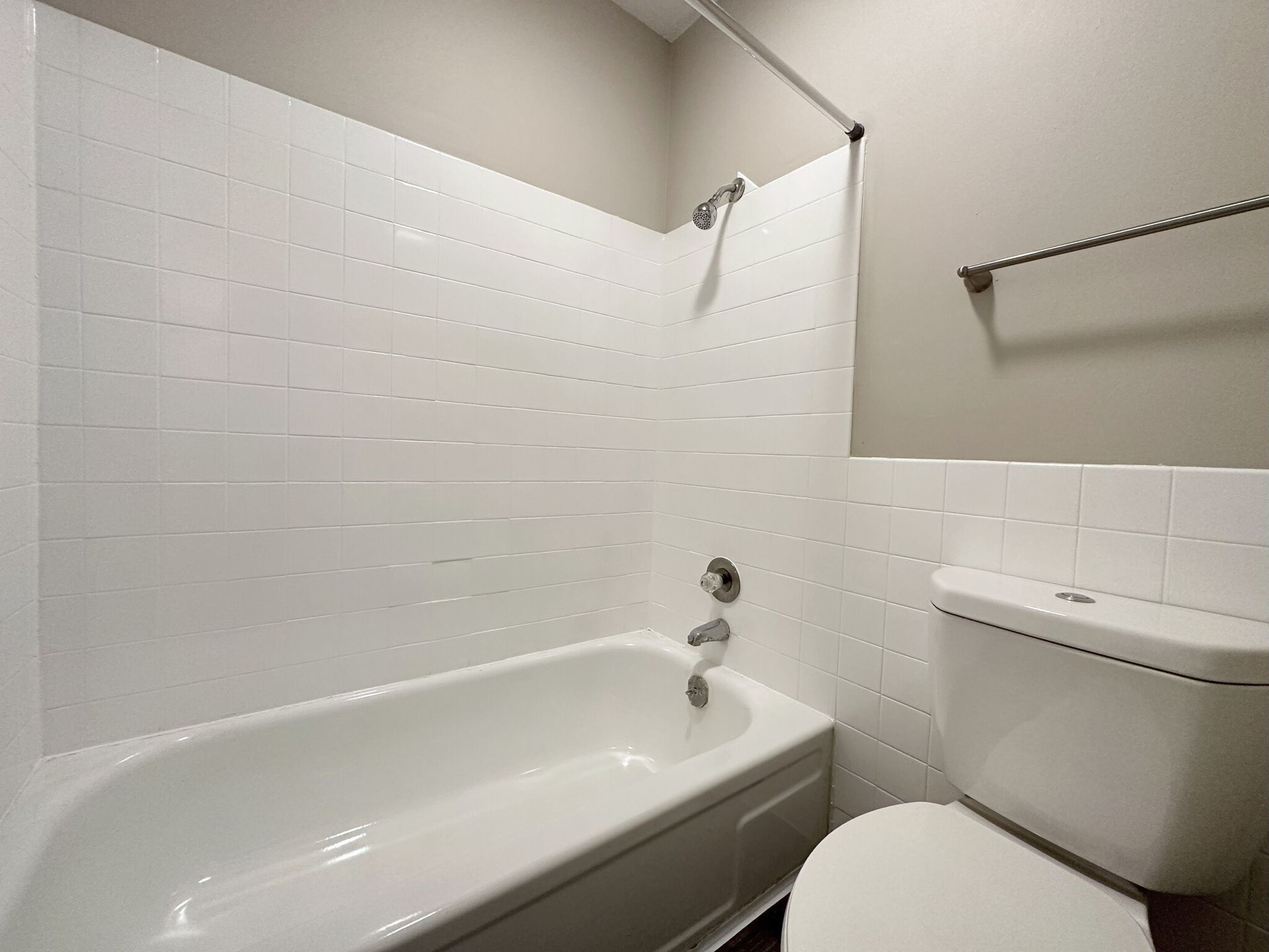 A bathroom with a bathtub , toilet and shower.