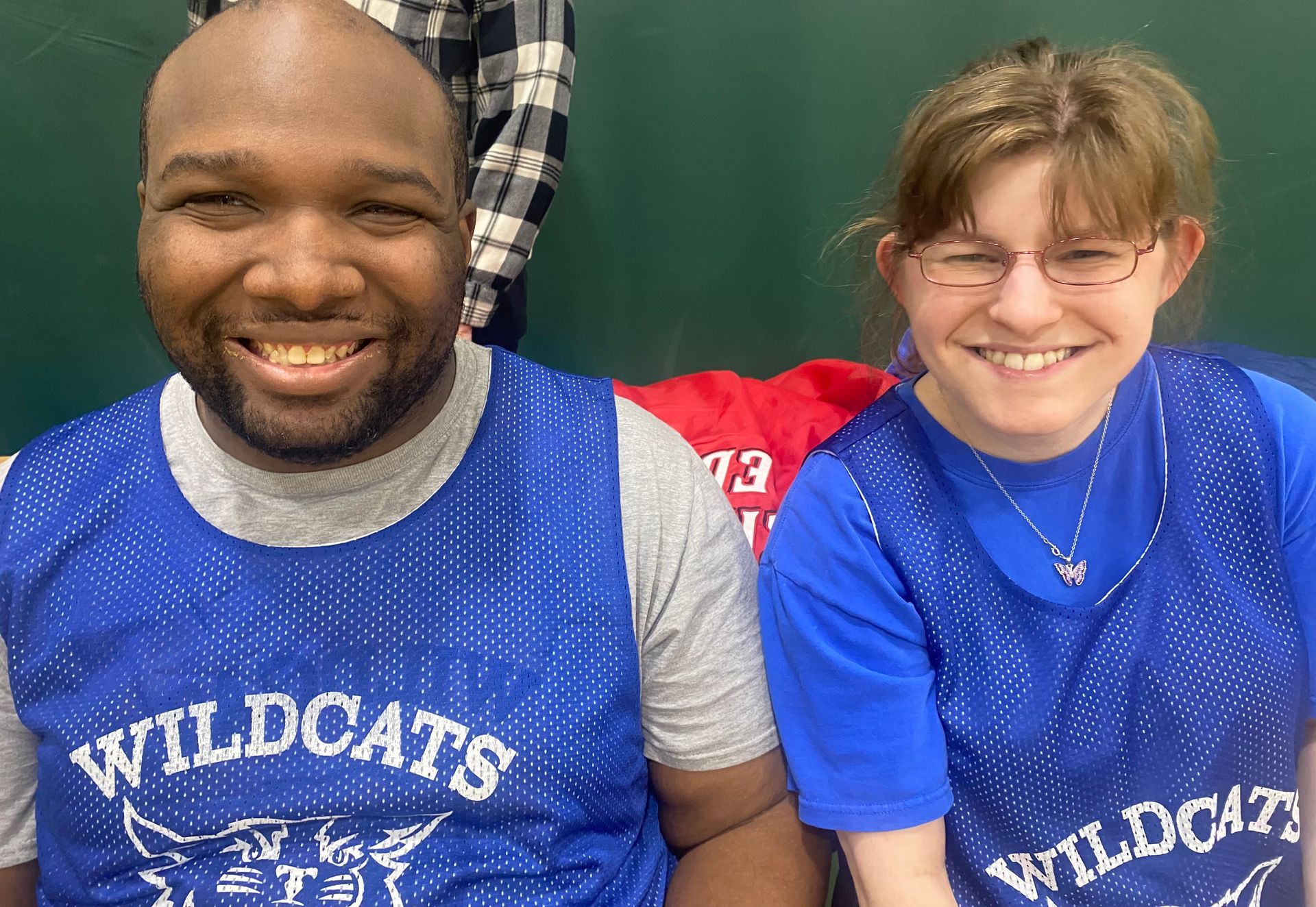 Two Wildcat Basketball players wearing blue jerseys smile for the camera
