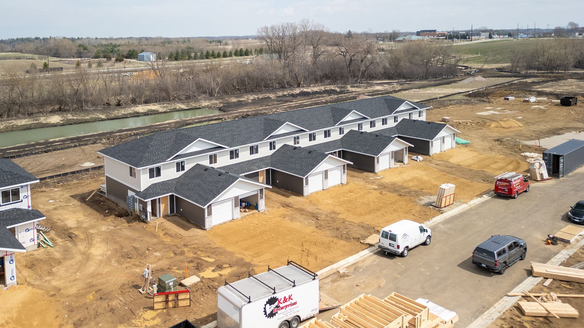 Aerial view of a new apartment complex under construction with trucks and building materials on site