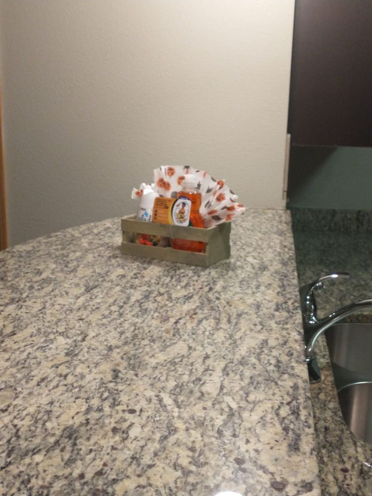 Wooden box on a granite countertop, holding Halloween treats and tissue.