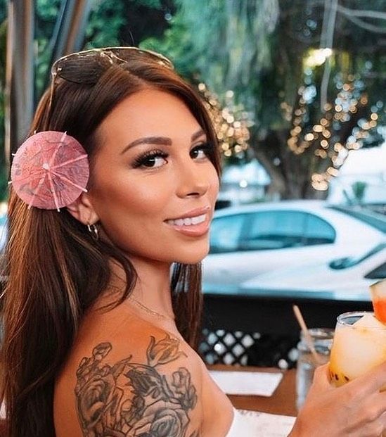 A Woman With An Umbrella In Her Hair Is Holding A Drink — Bloom Skin Brows & Beauty In Bungalow, QLD