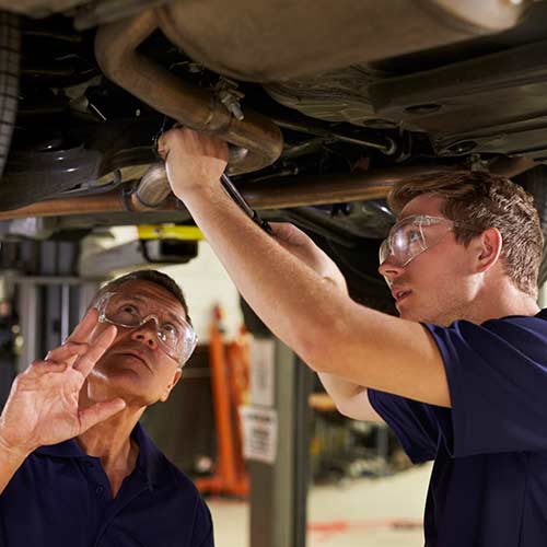 Car Inspection — Two Mechanics Working Underneath Car Together in Fairfield, OH