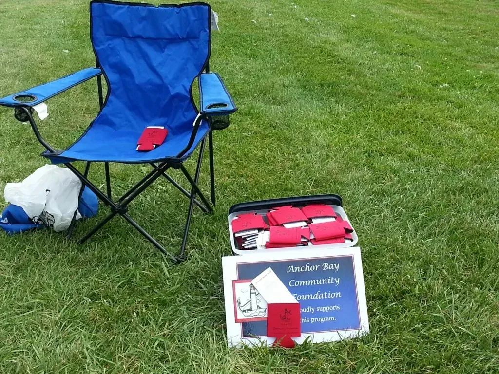 A lawn chair next to an Anchor Bay Community Foundation sign.