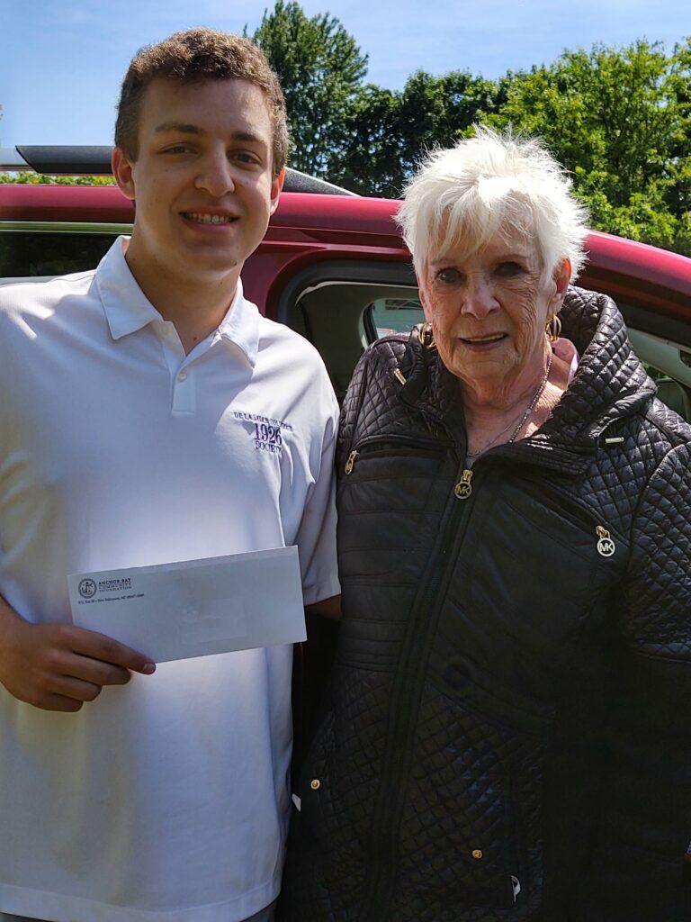 A young man holding an envelope standing next to a senior woman.